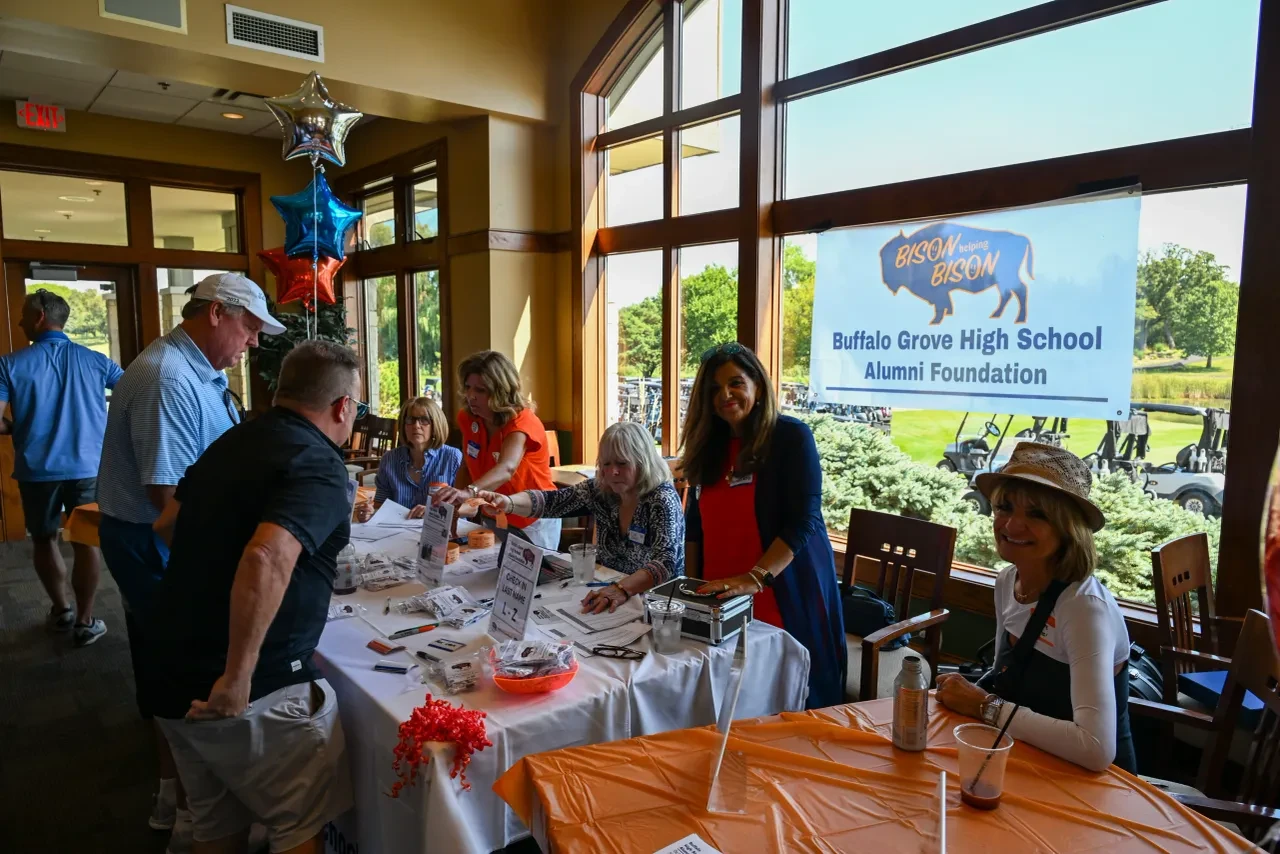 Alumni Foundation registration table with Bison Helping Bison banner