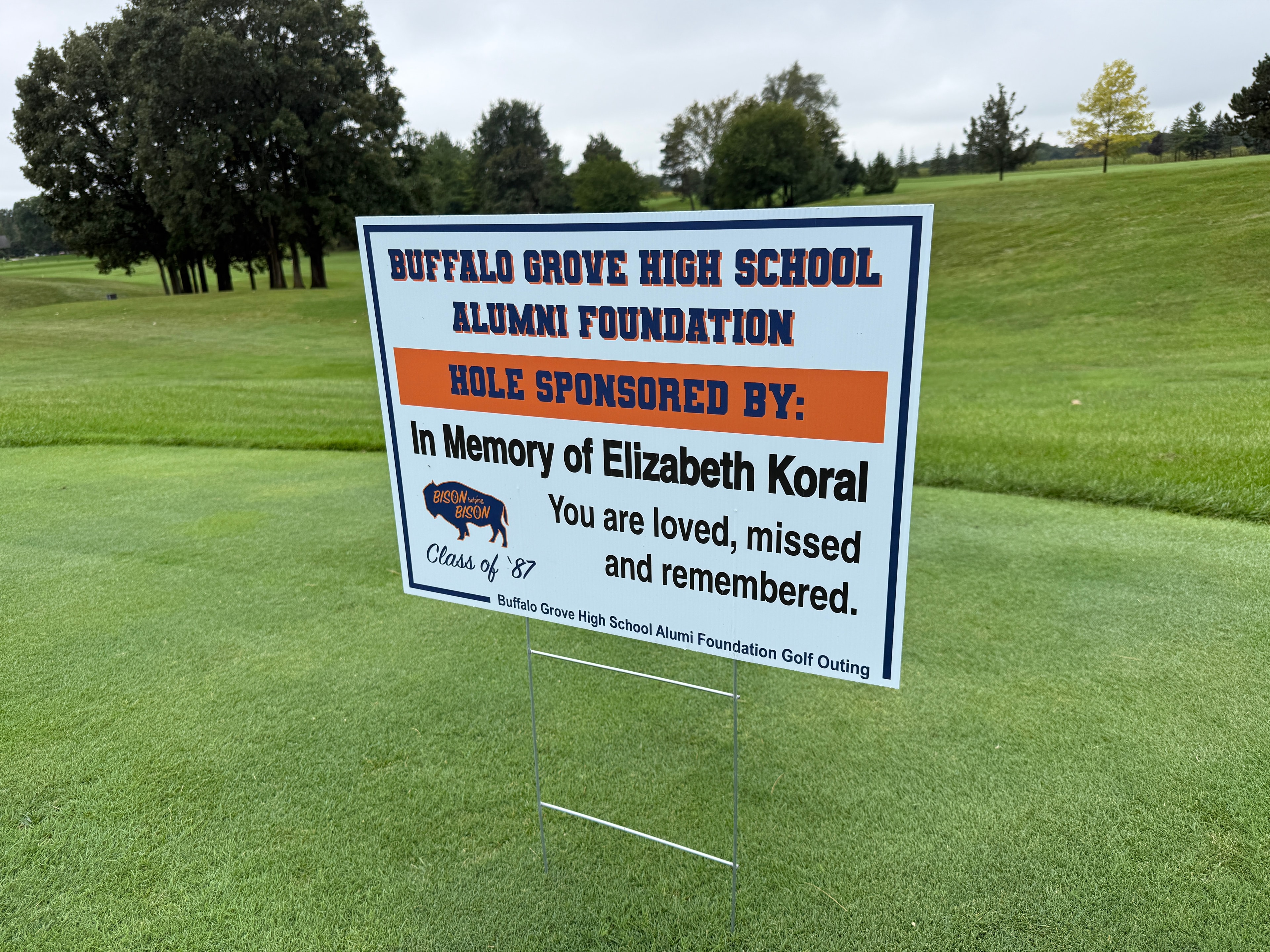 Memorial golf course sign on green field