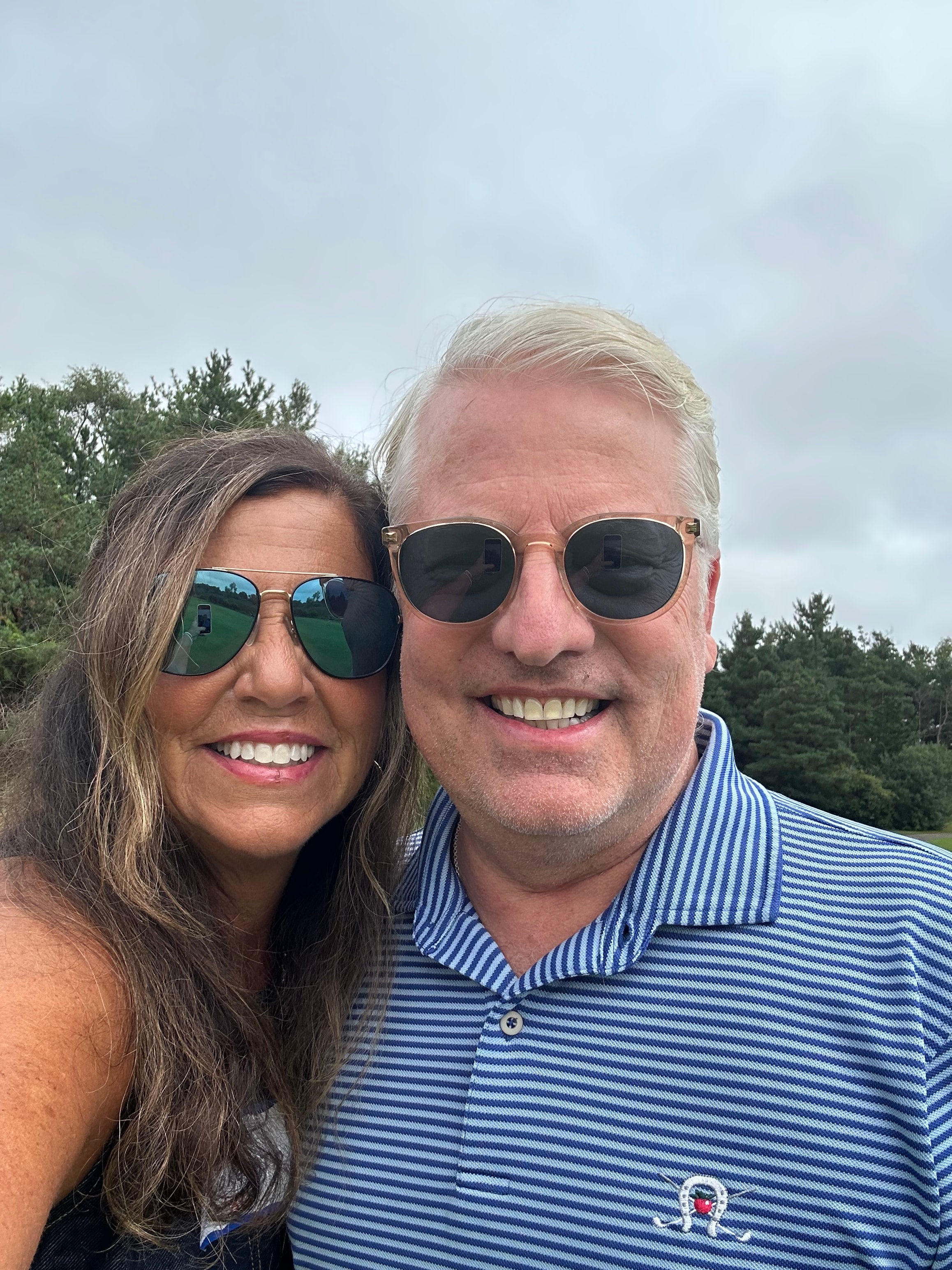 Couple wearing sunglasses smiling outdoors