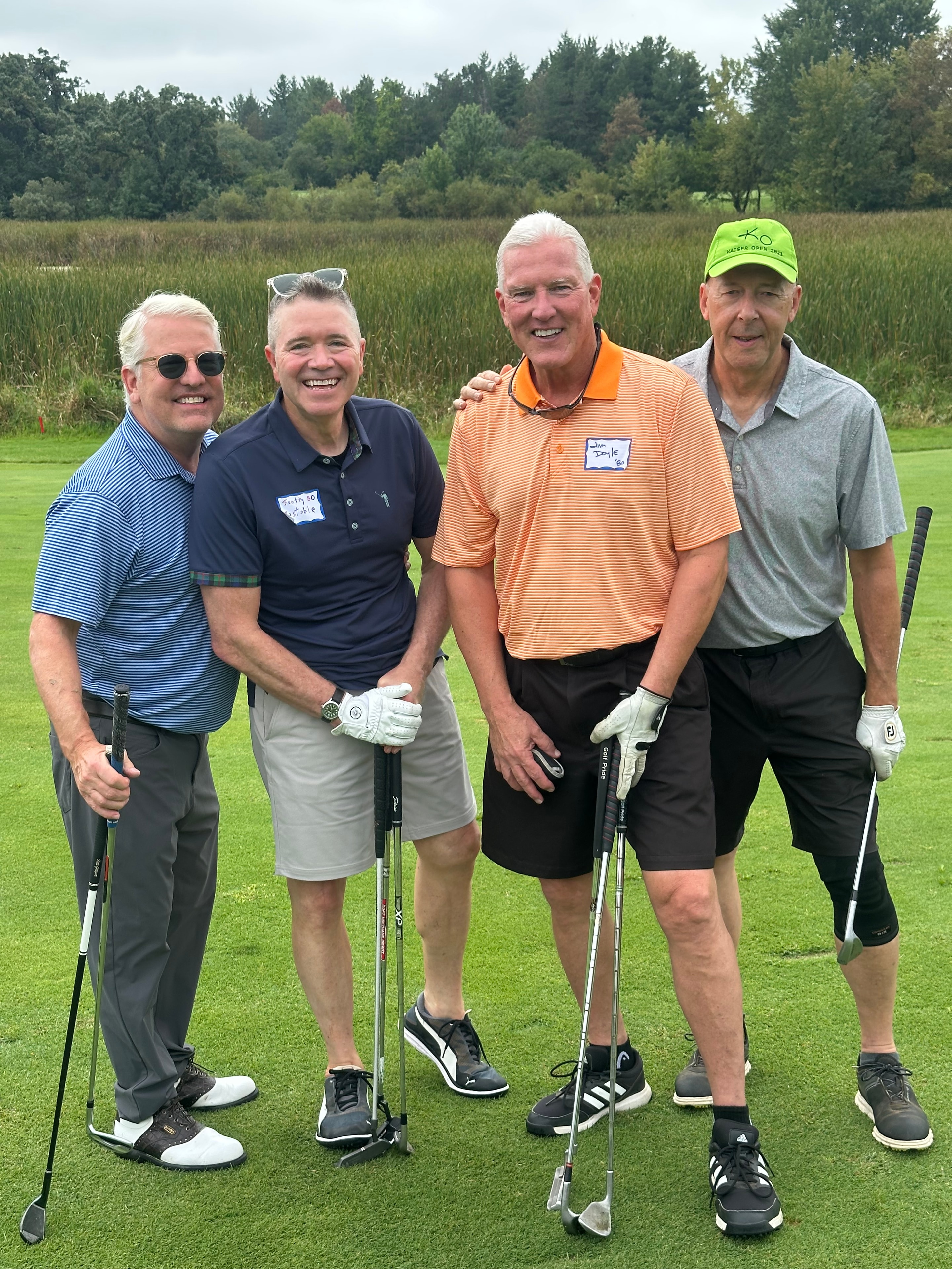 Four men golfing together on course