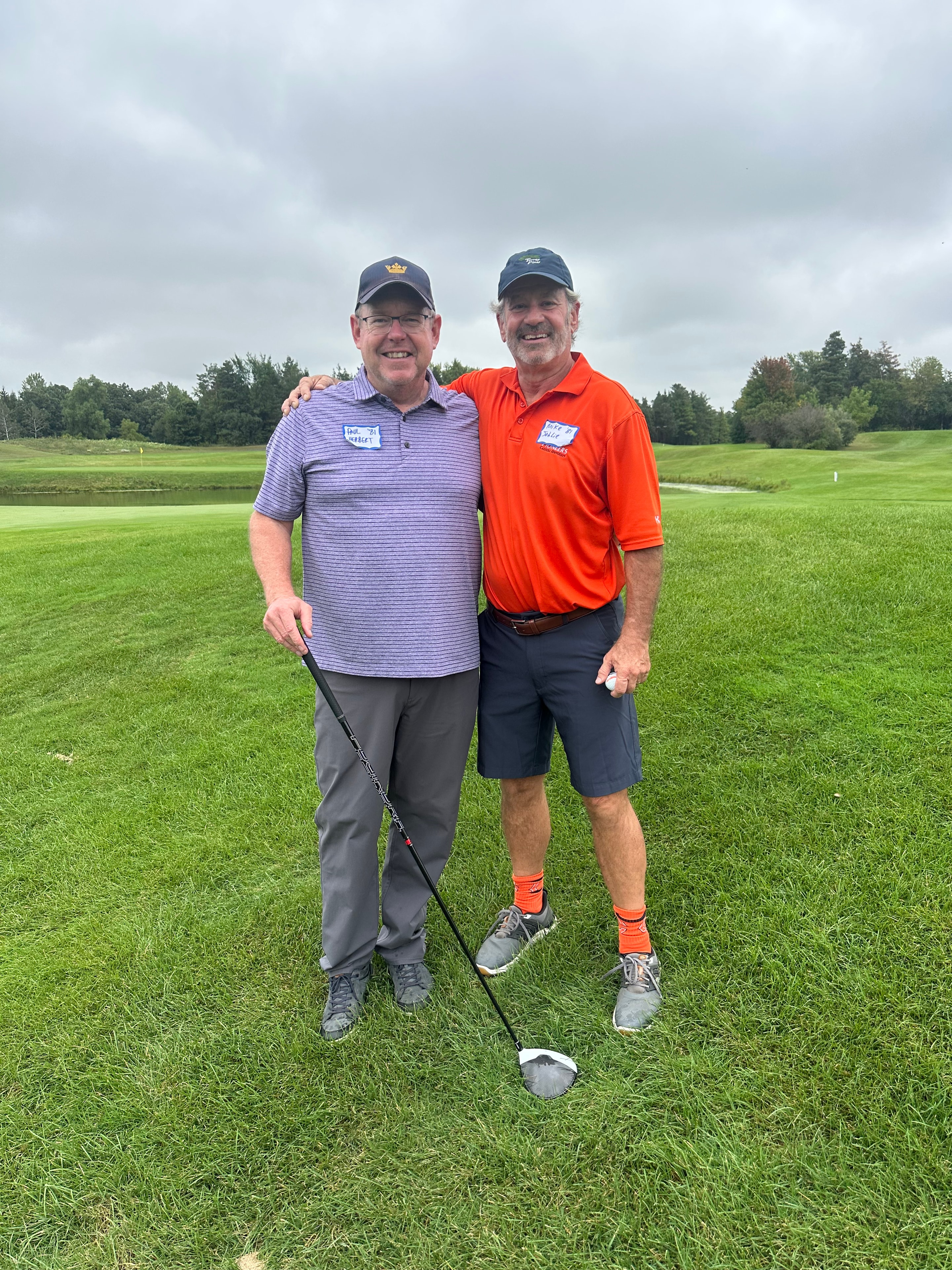 Two men posing on golf course fairway