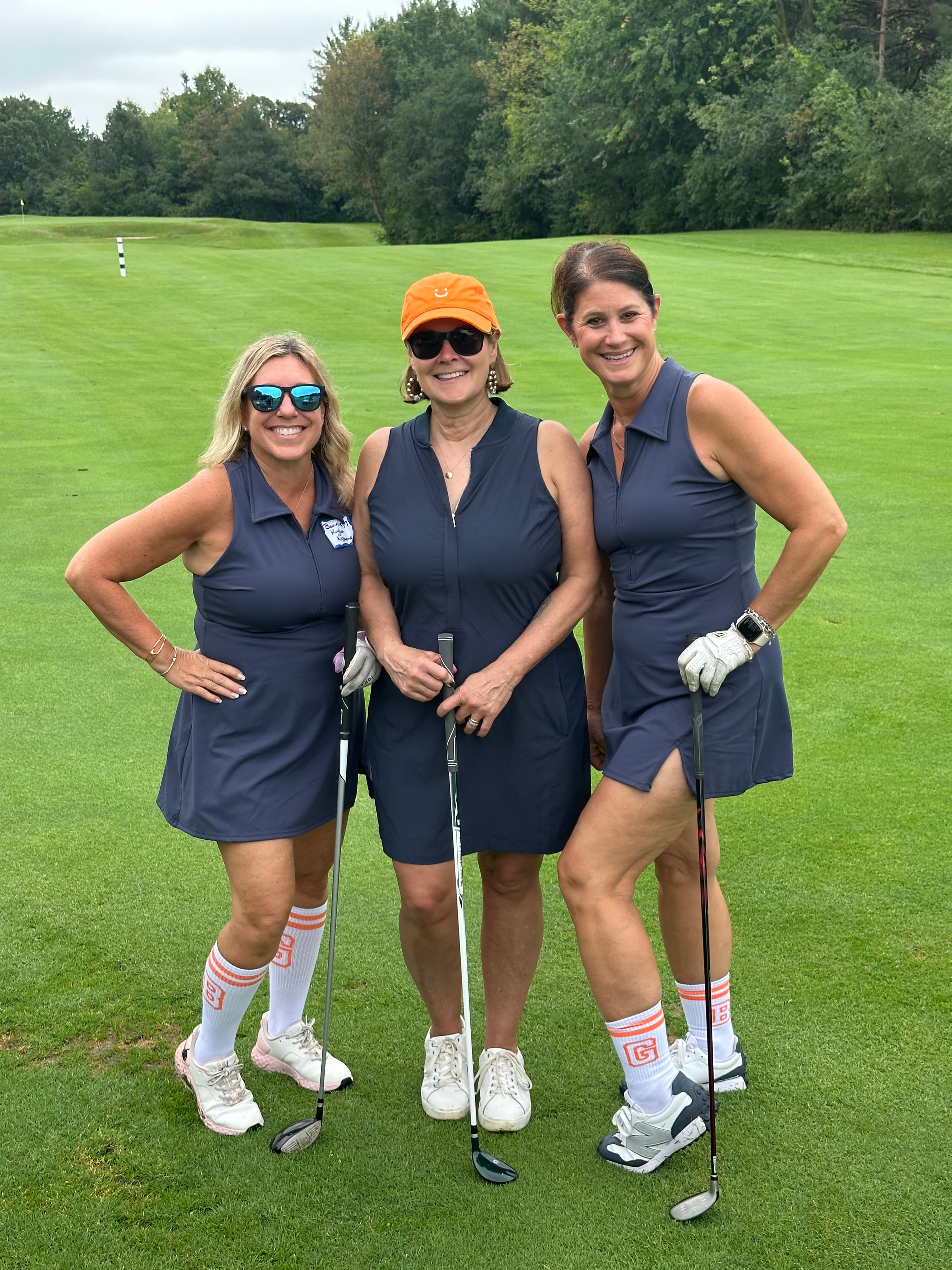 Three women golfing on green course