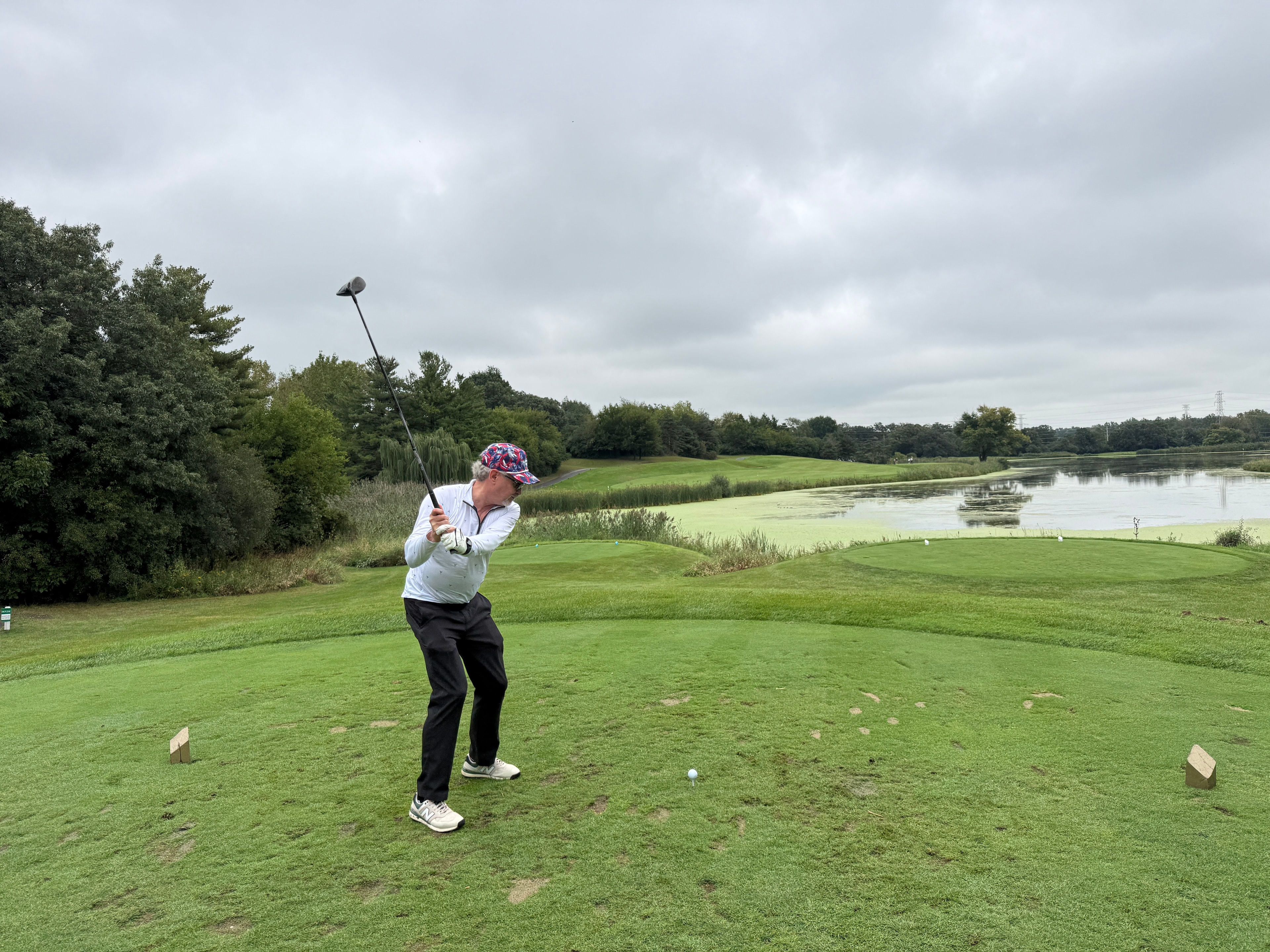 Golfer swinging on waterside course