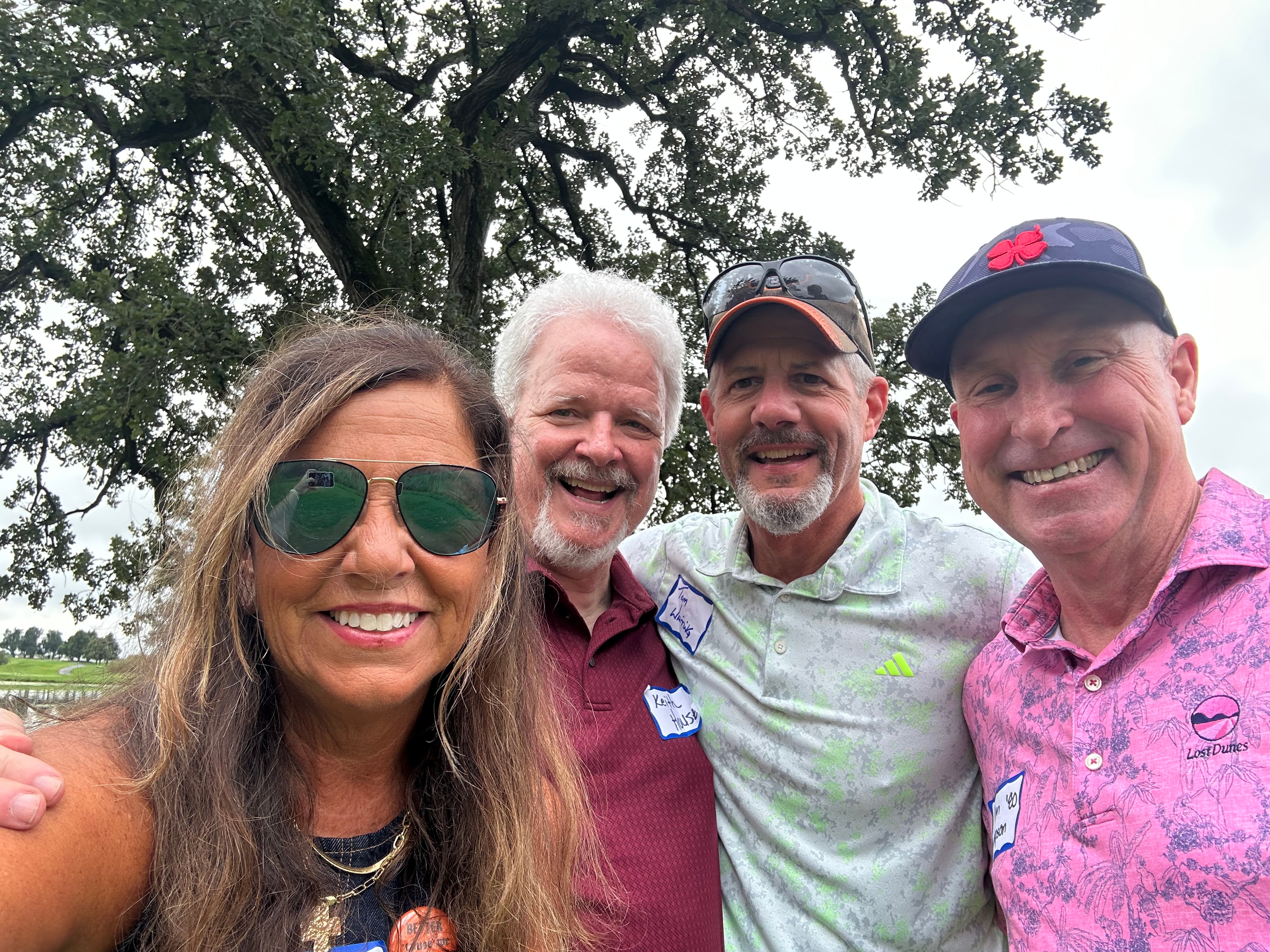Four people smiling at golf outing