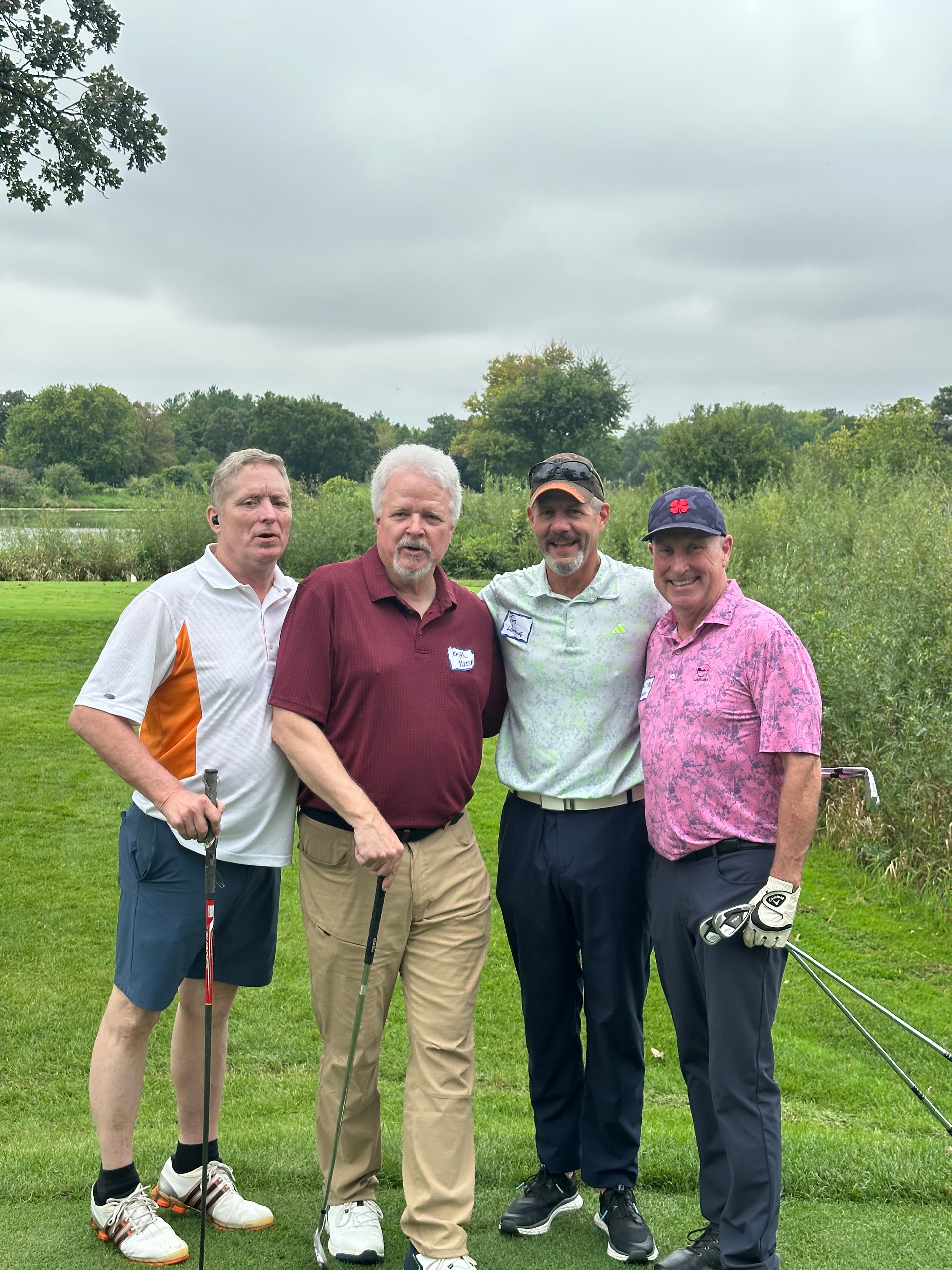Four men posing on golf course