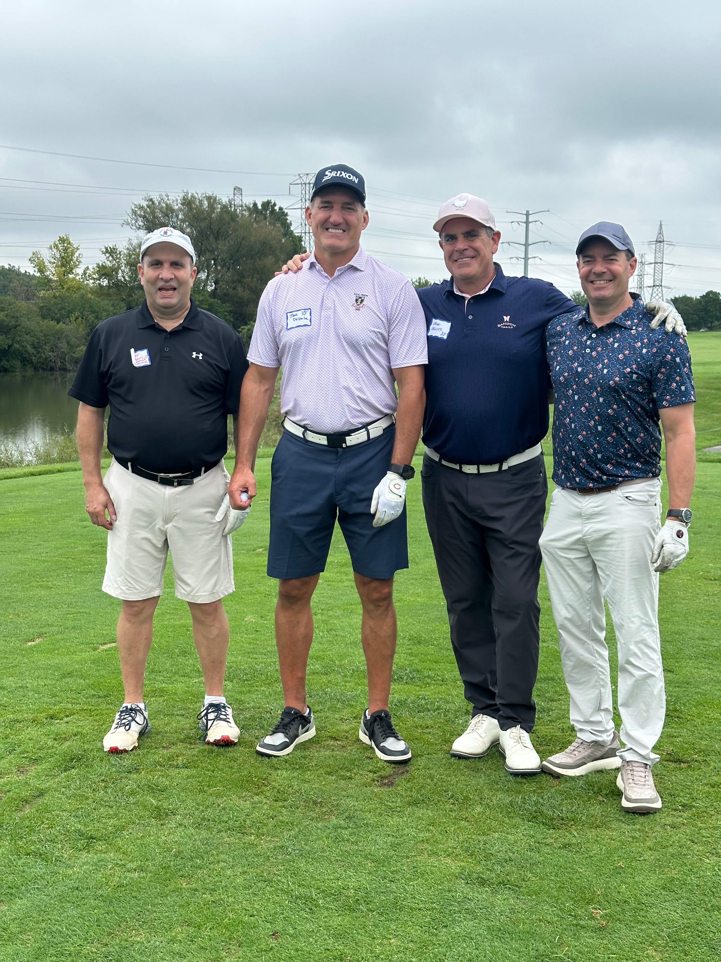 Four men posing on golf course