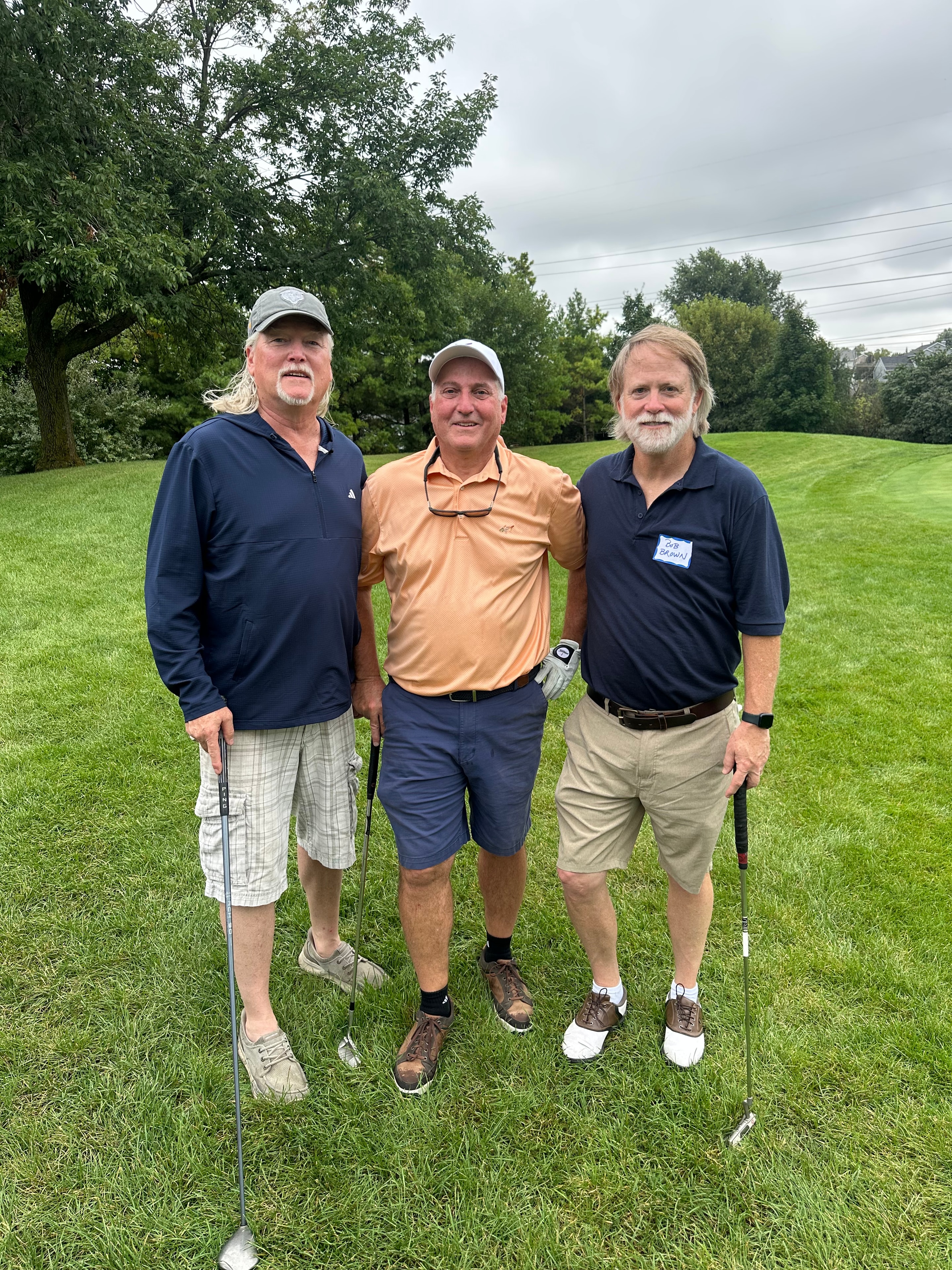 Three men posing on golf course