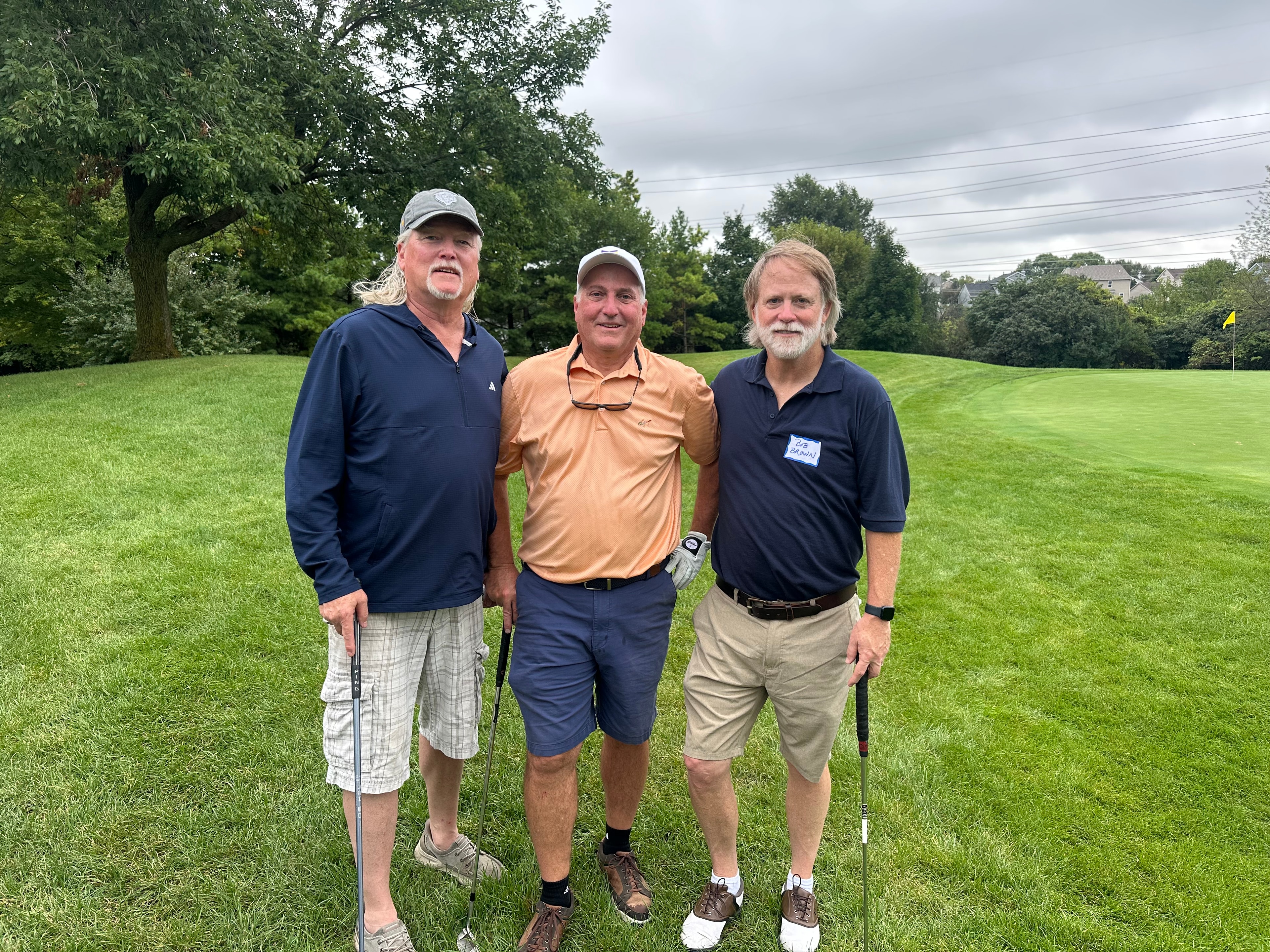 Three men posing on golf course