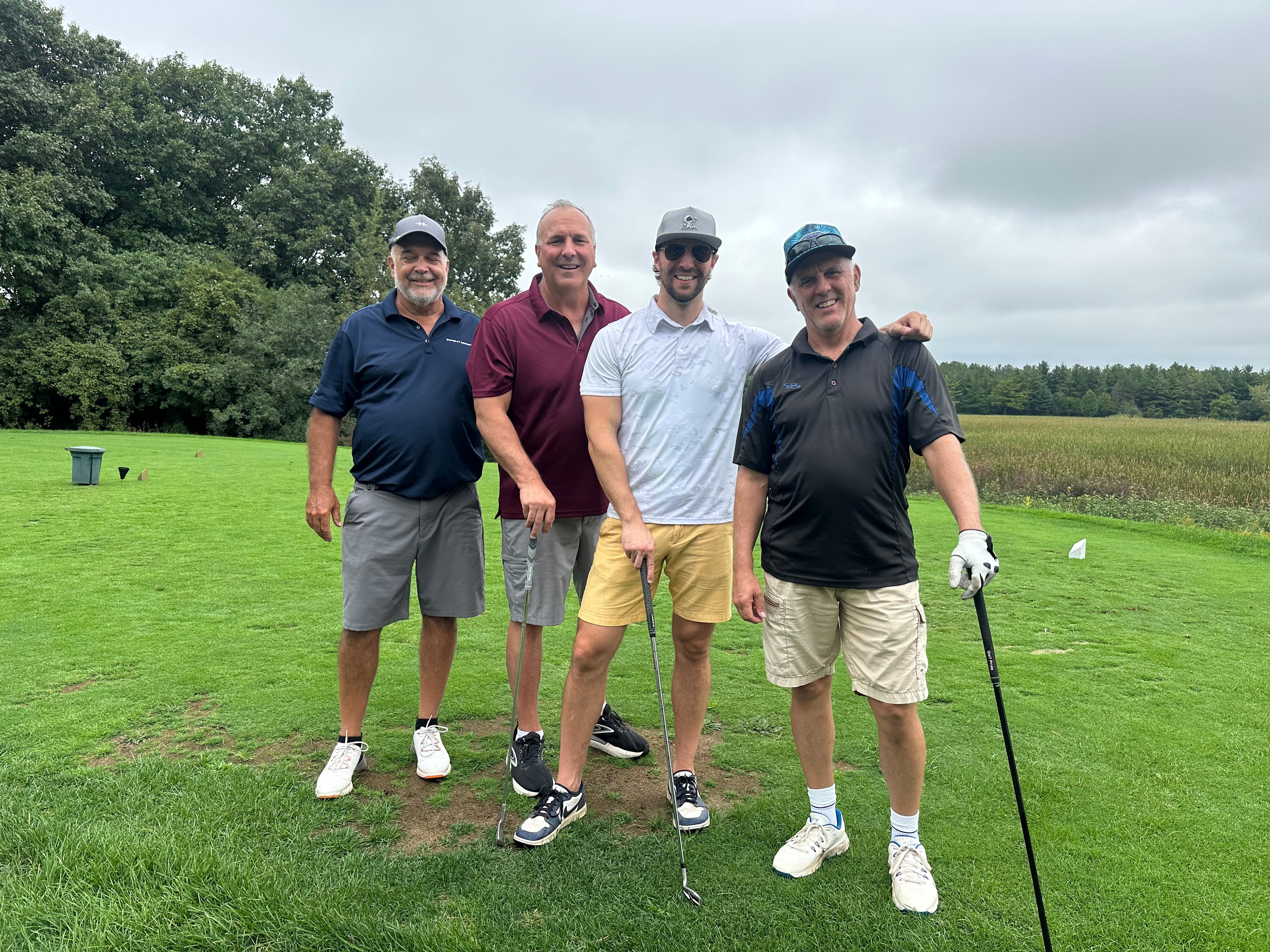 Four men golfing together on course