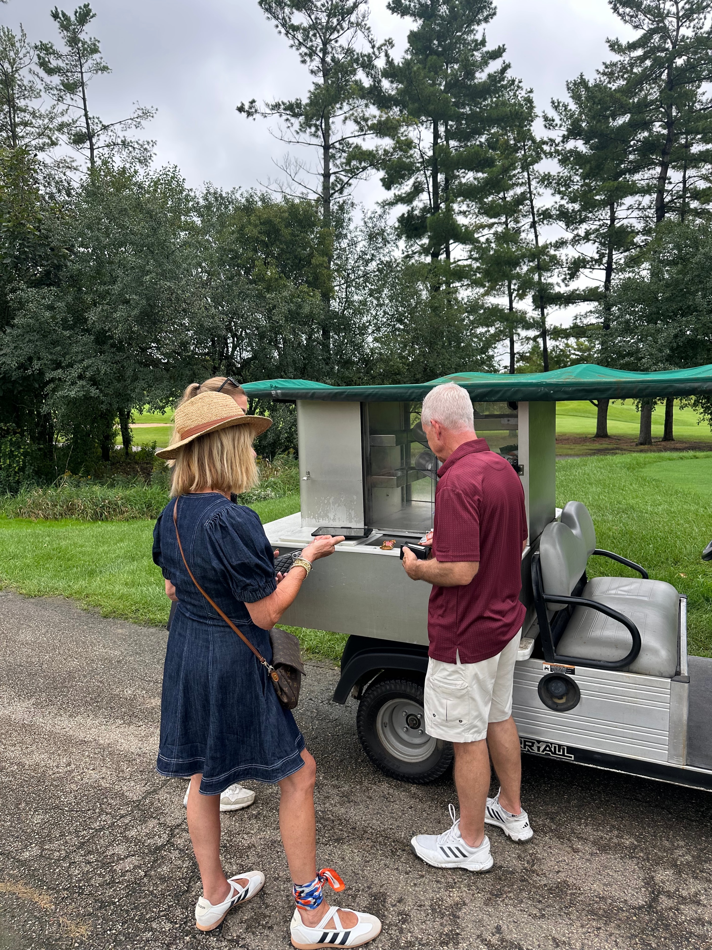 Couple ordering food at golf cart window