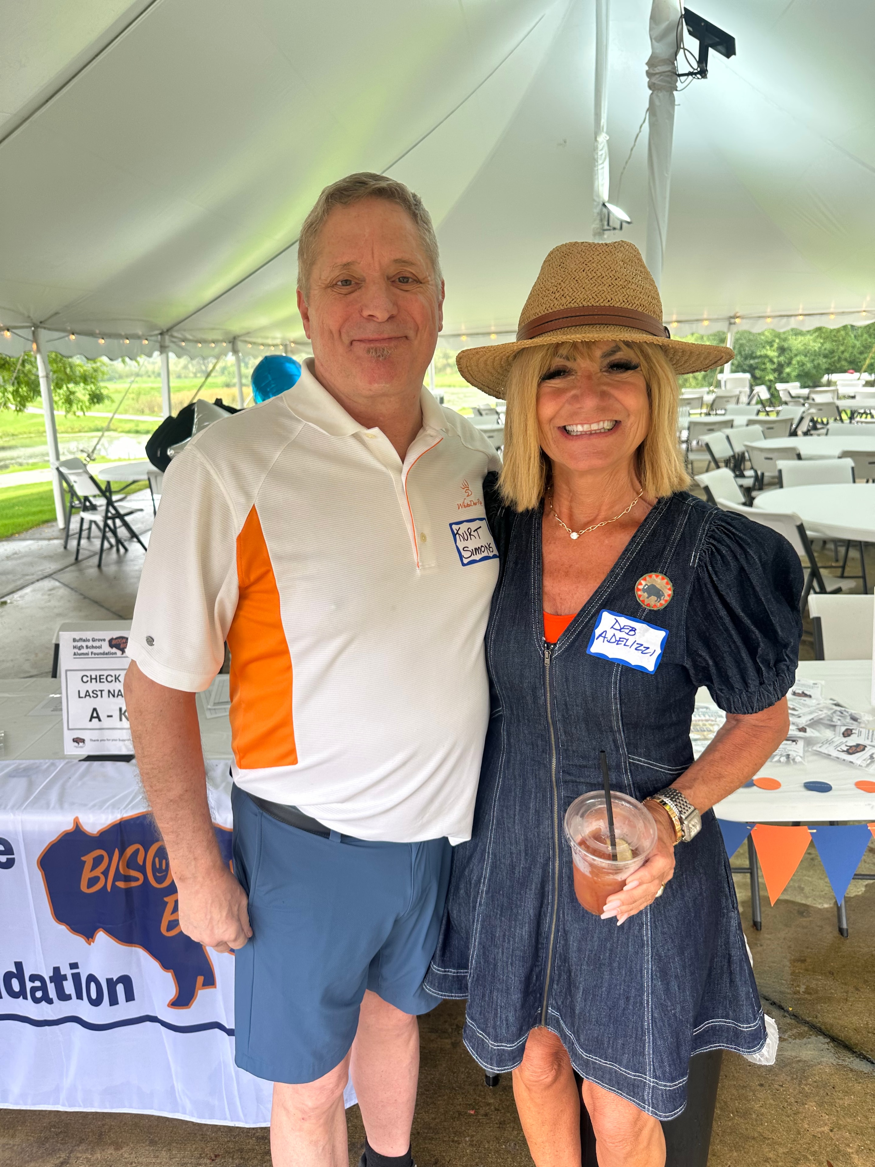 Two people posing at outdoor event tent
