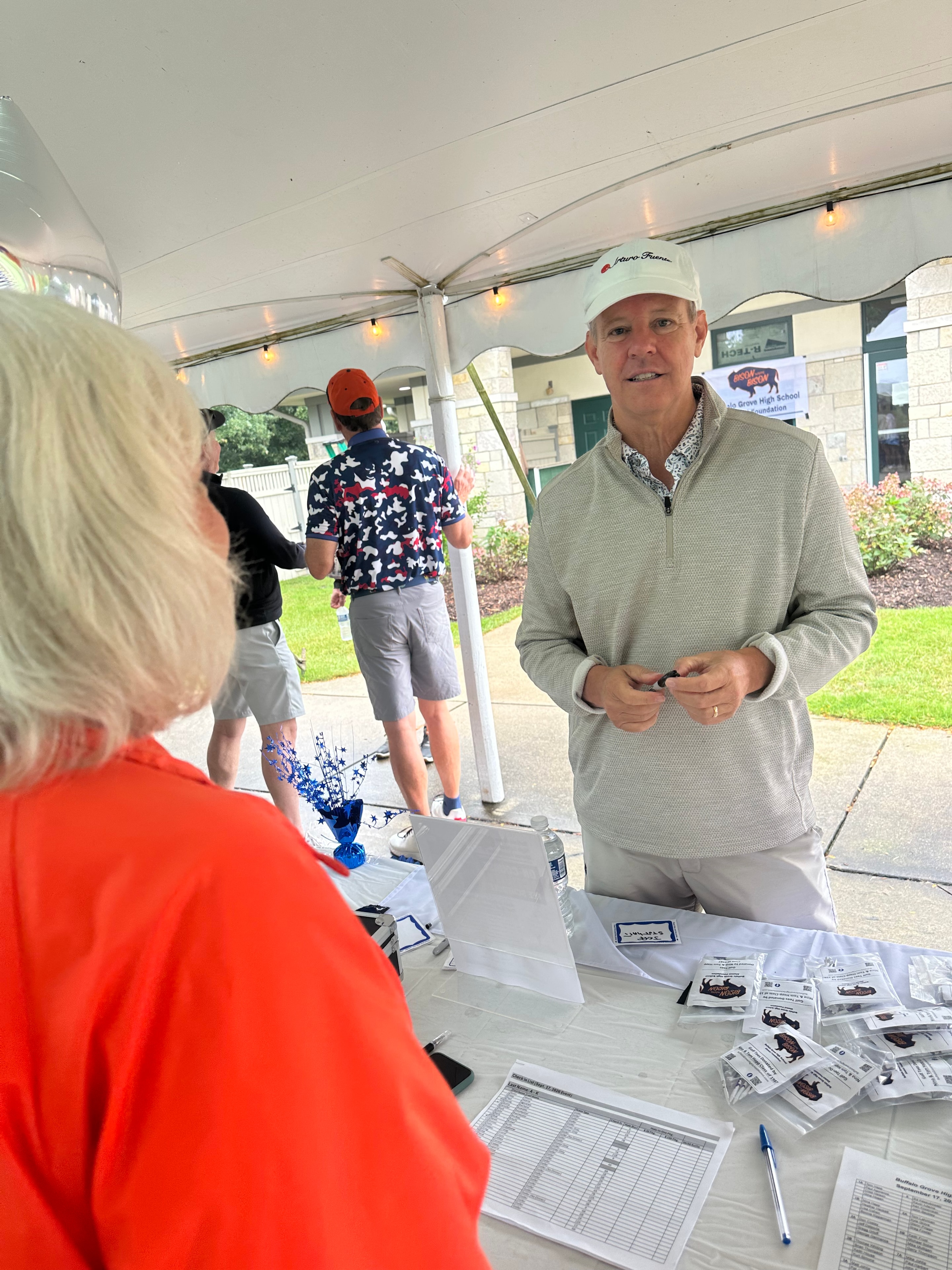 Man speaking with woman at outdoor tent