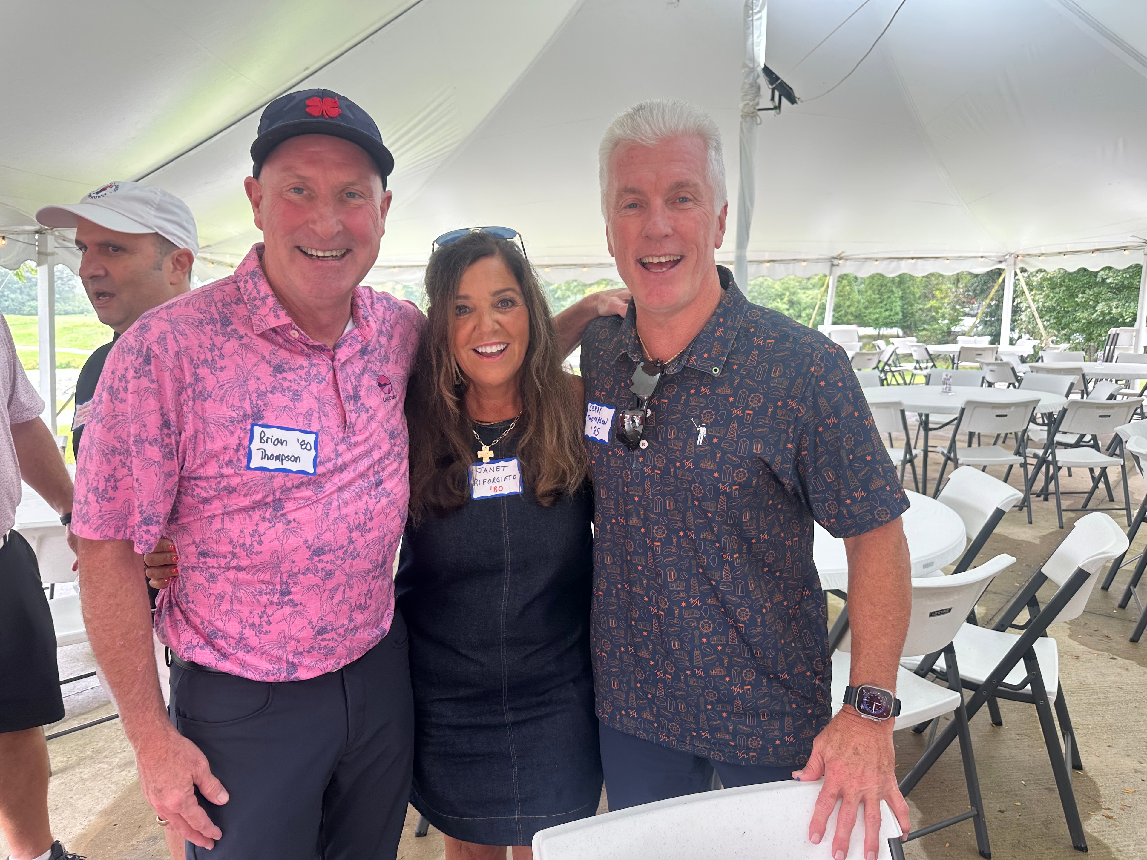 Four people smiling at outdoor event tent