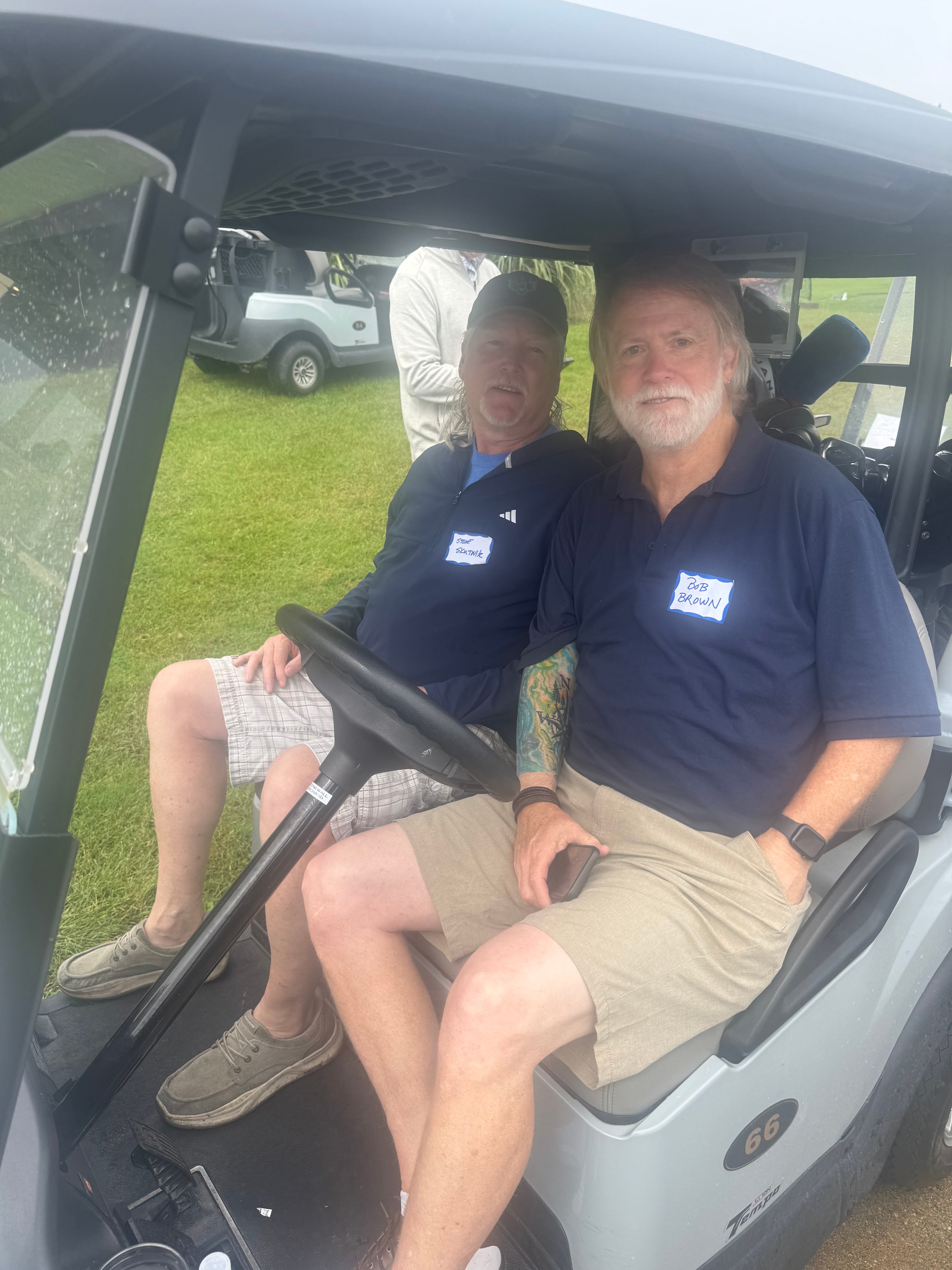 Two men sitting in golf cart
