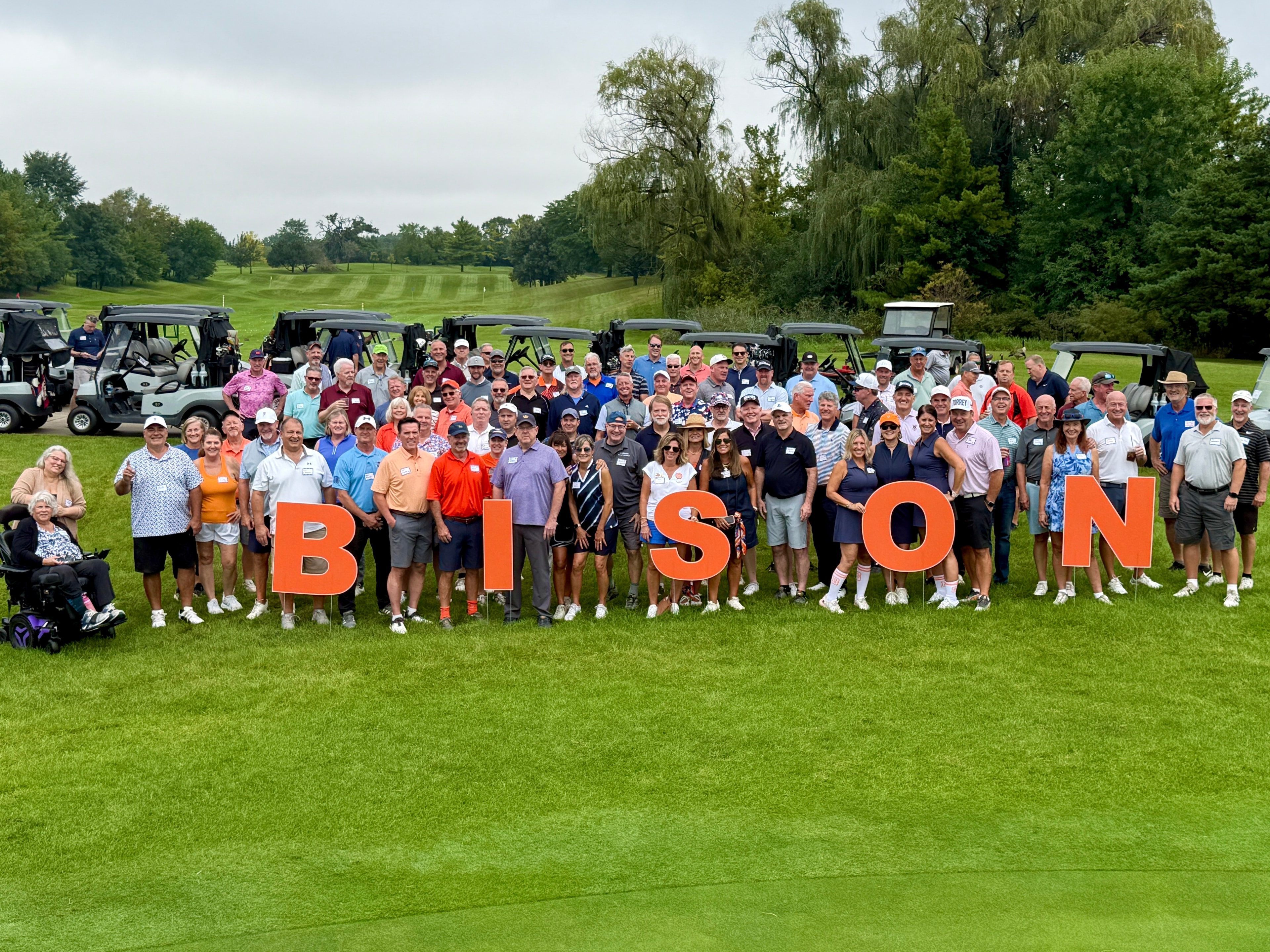 Large group posing at golf course charity event