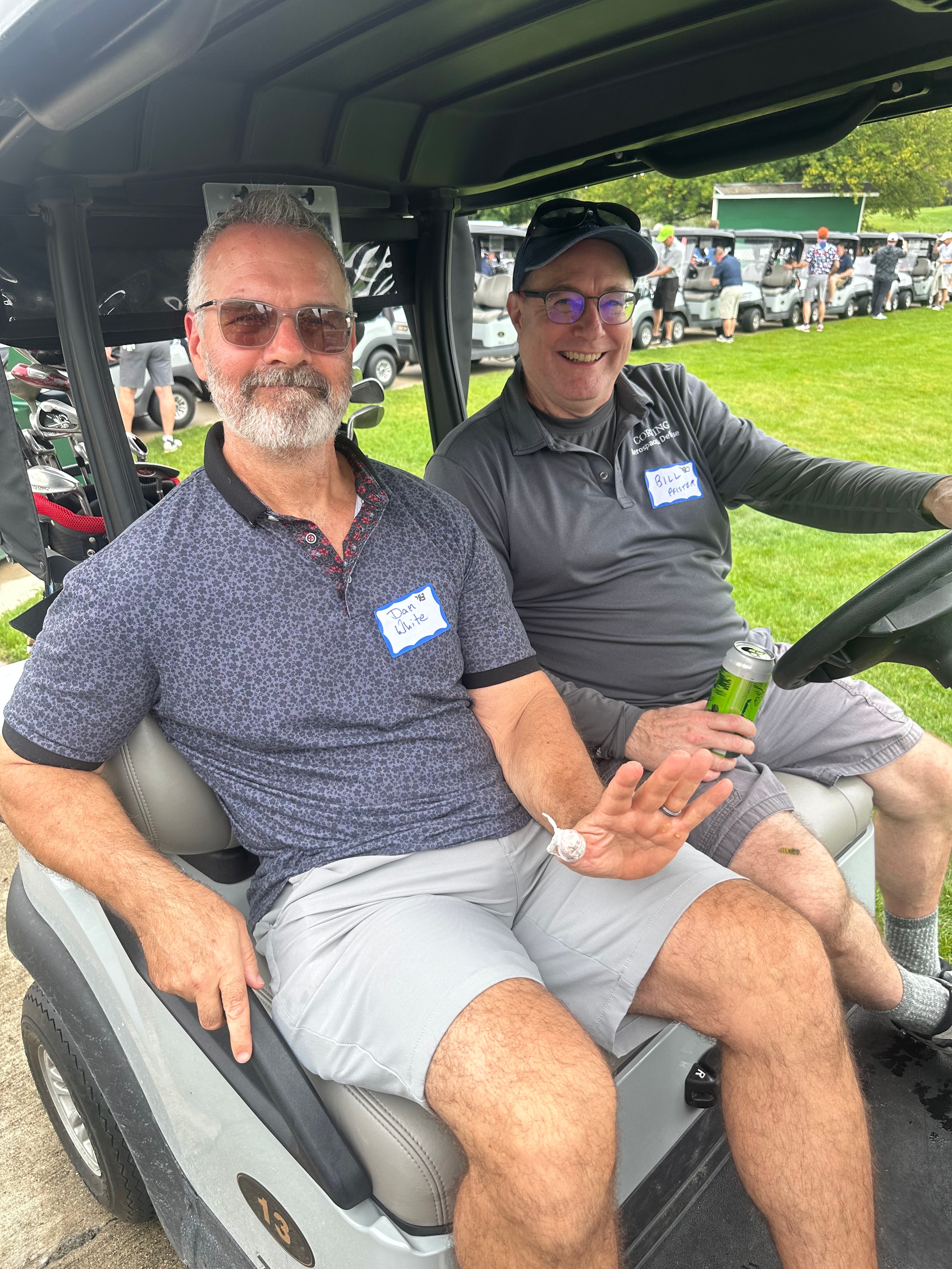 Two men in golf cart at tournament