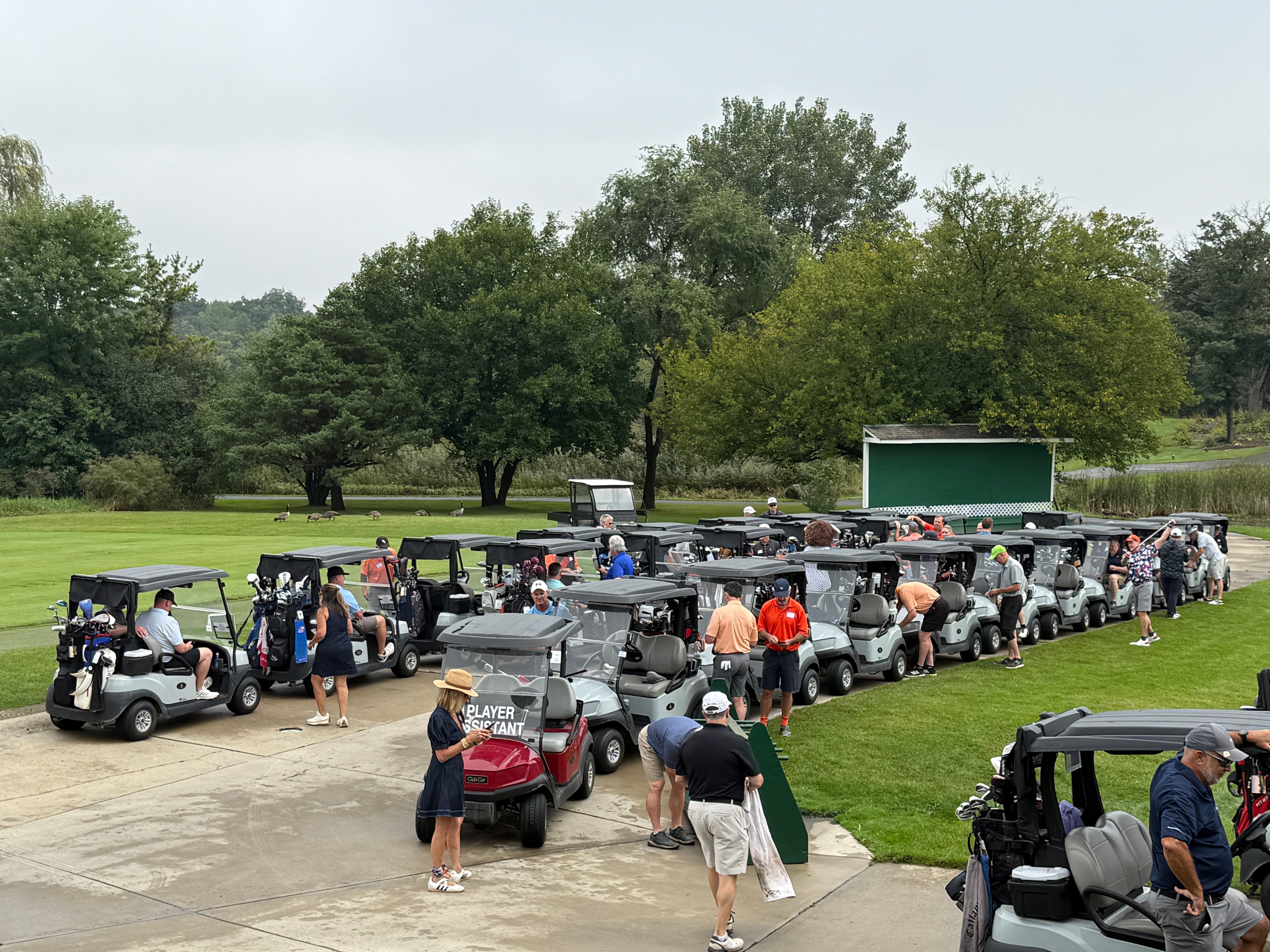 Golf tournament participants gathering with carts