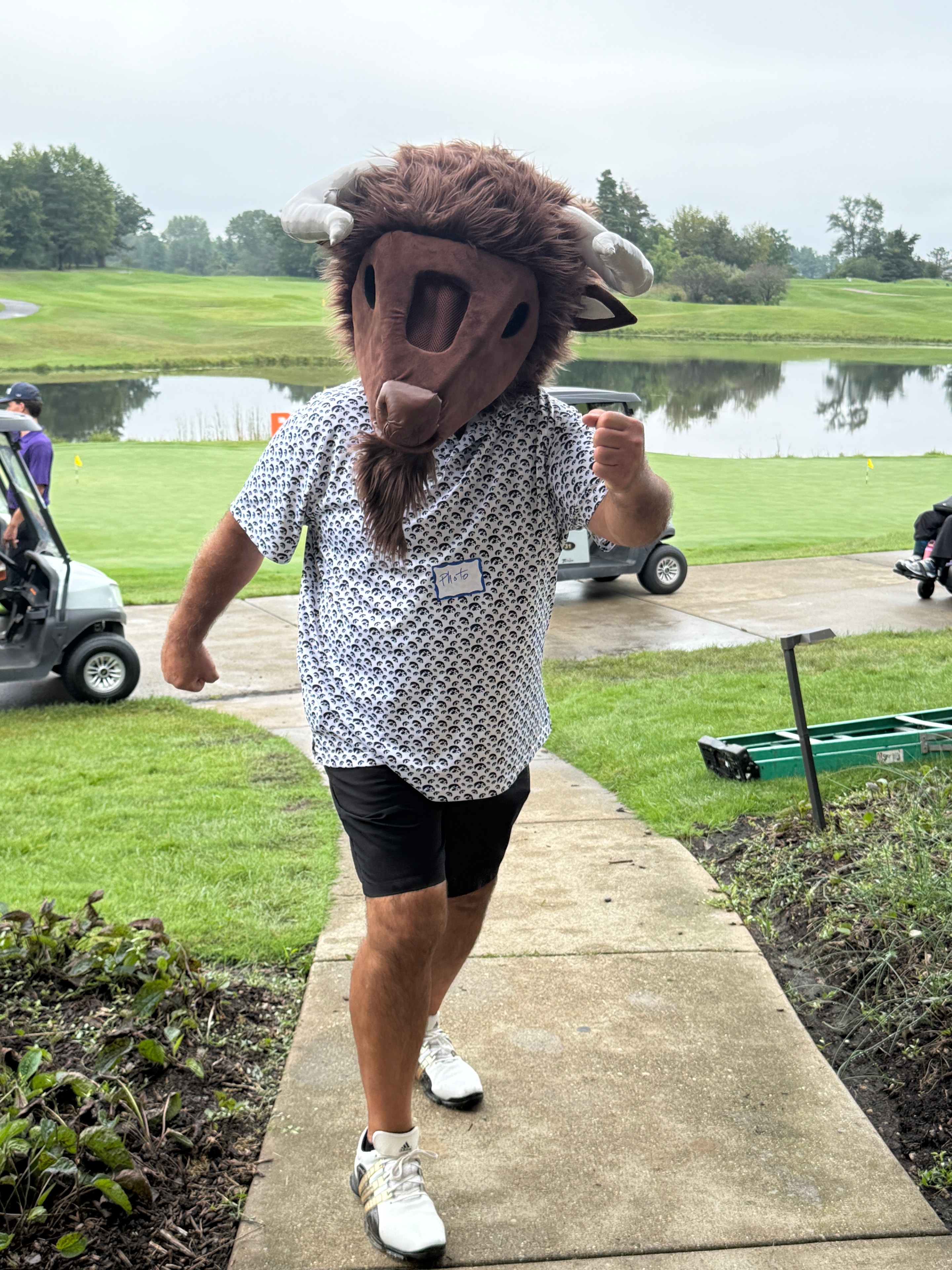 Person in Bison mascot costume golfing