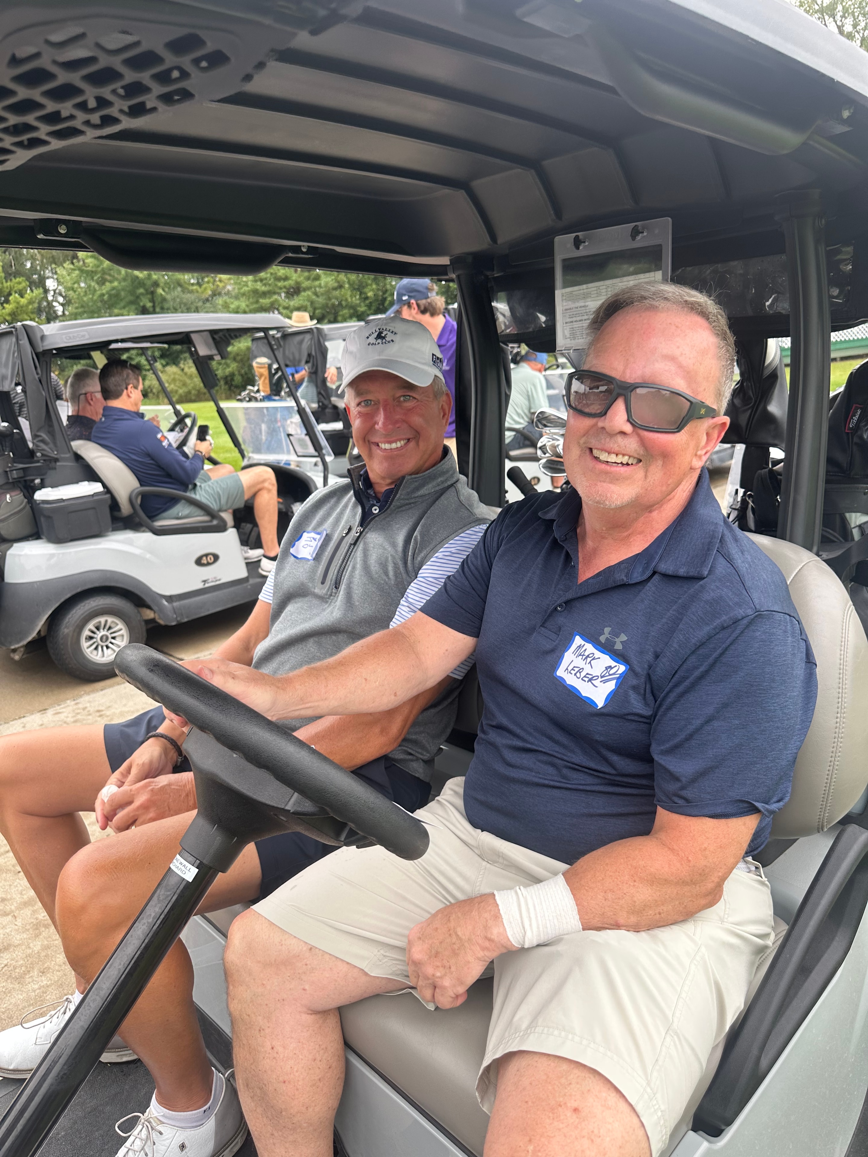 Men smiling in golf cart outdoors