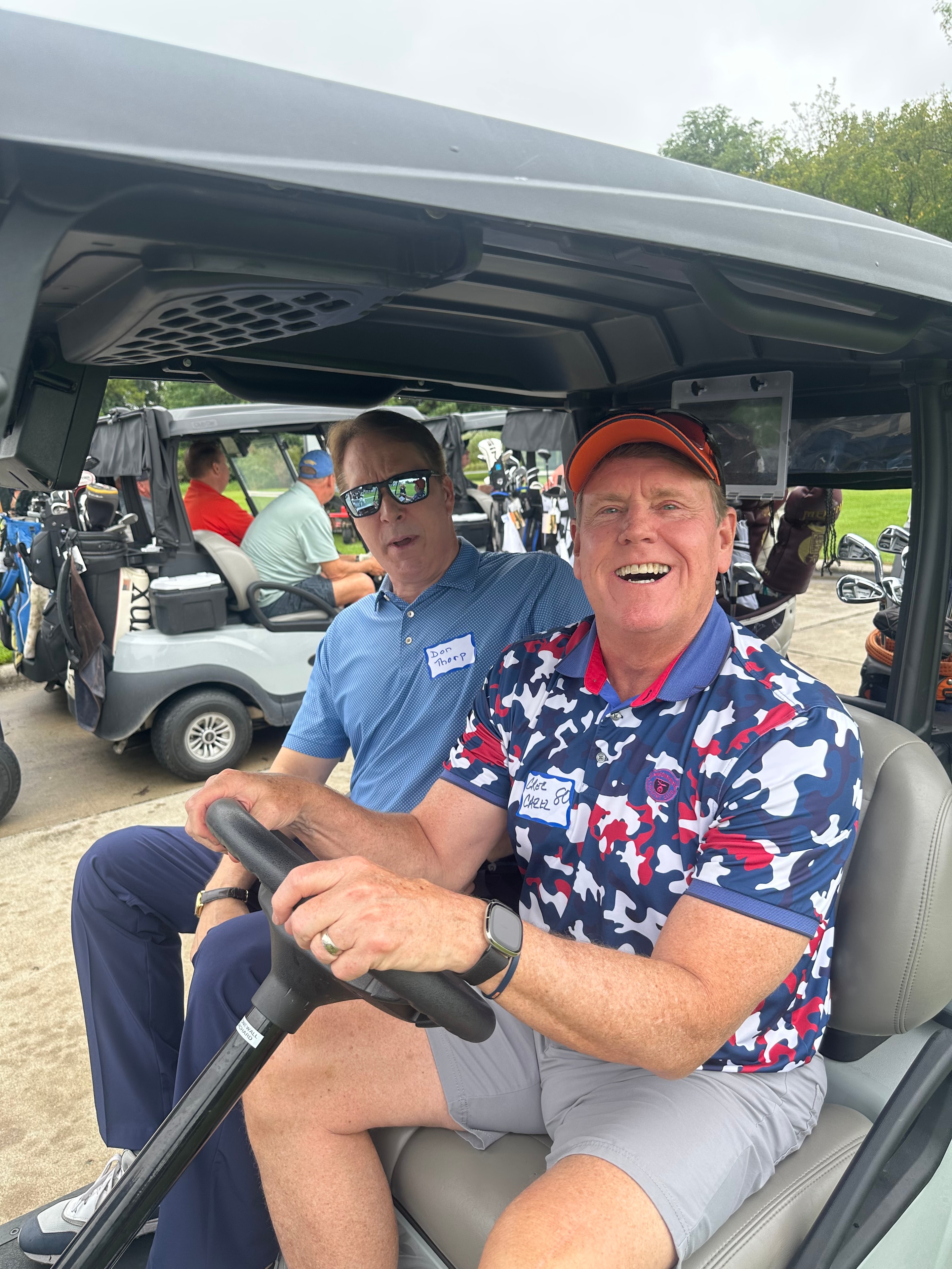 Men smiling in golf cart outdoors