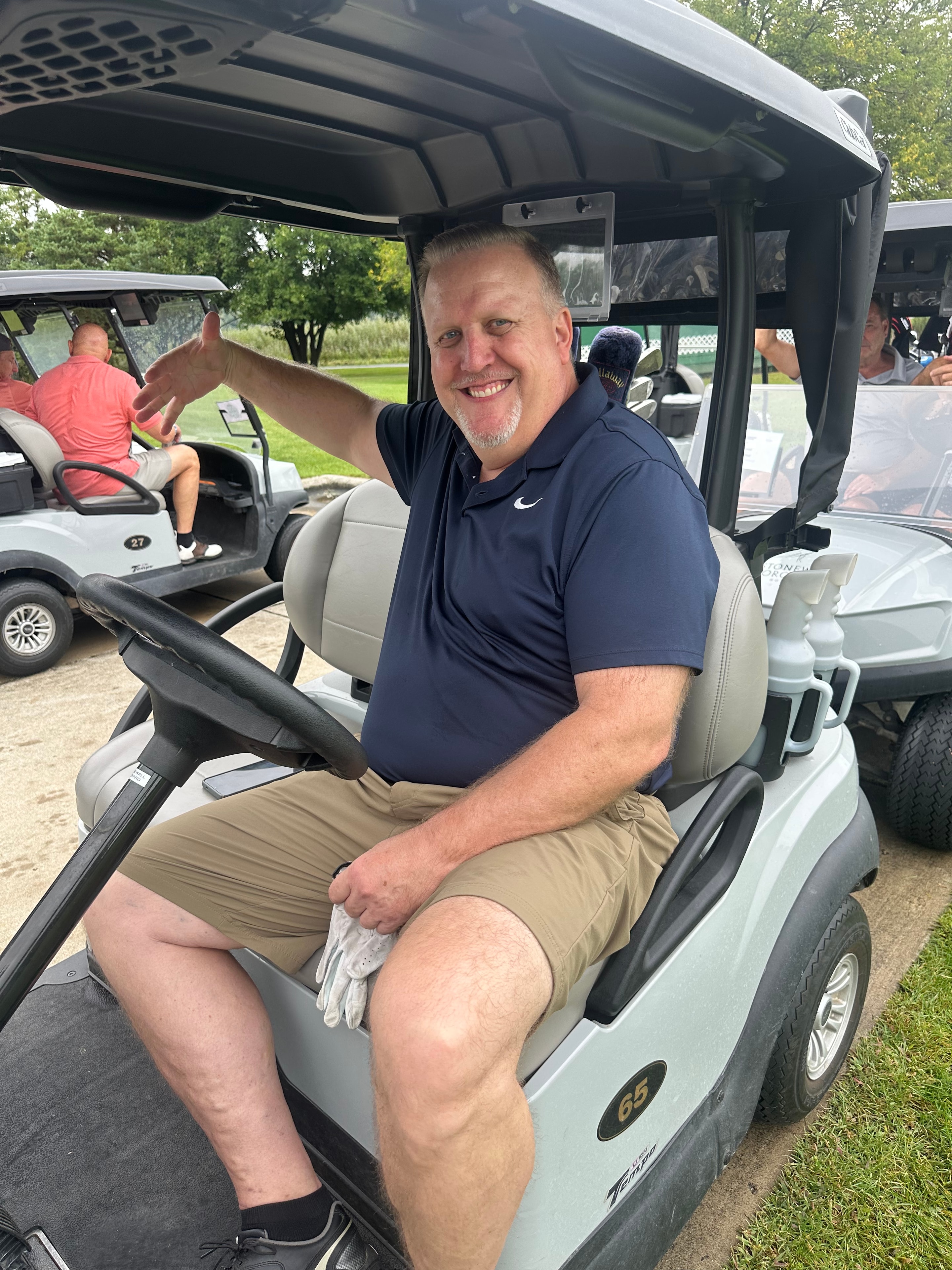 Man smiling in golf cart outdoors