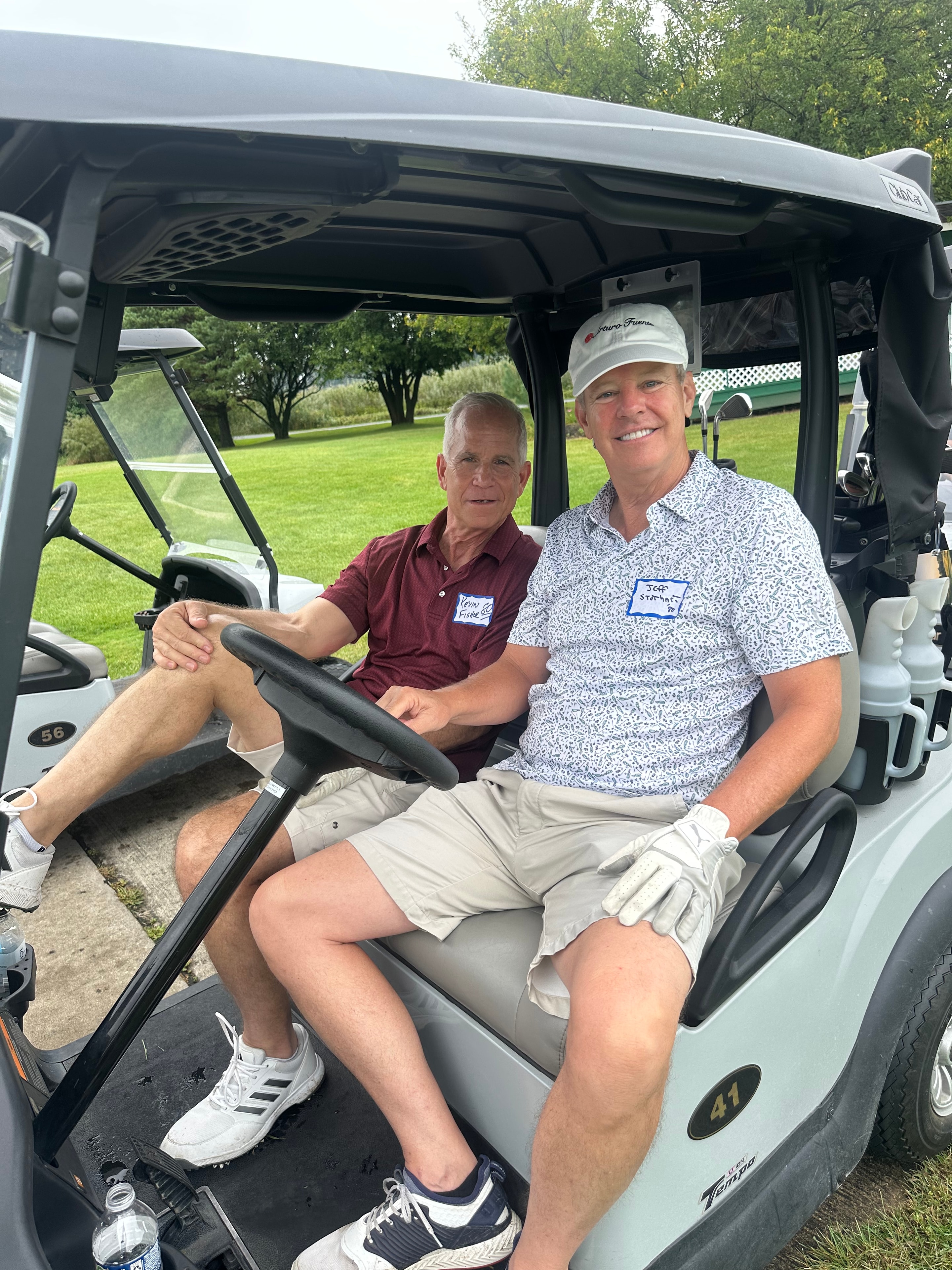 Two men in golf cart on course