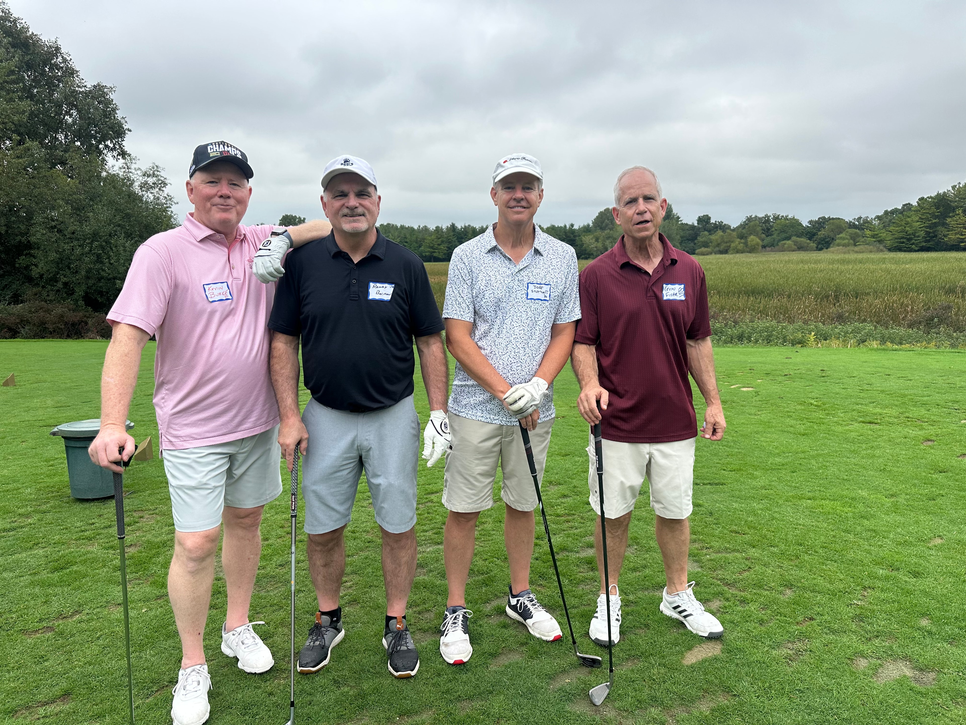 Four men golfing on green course
