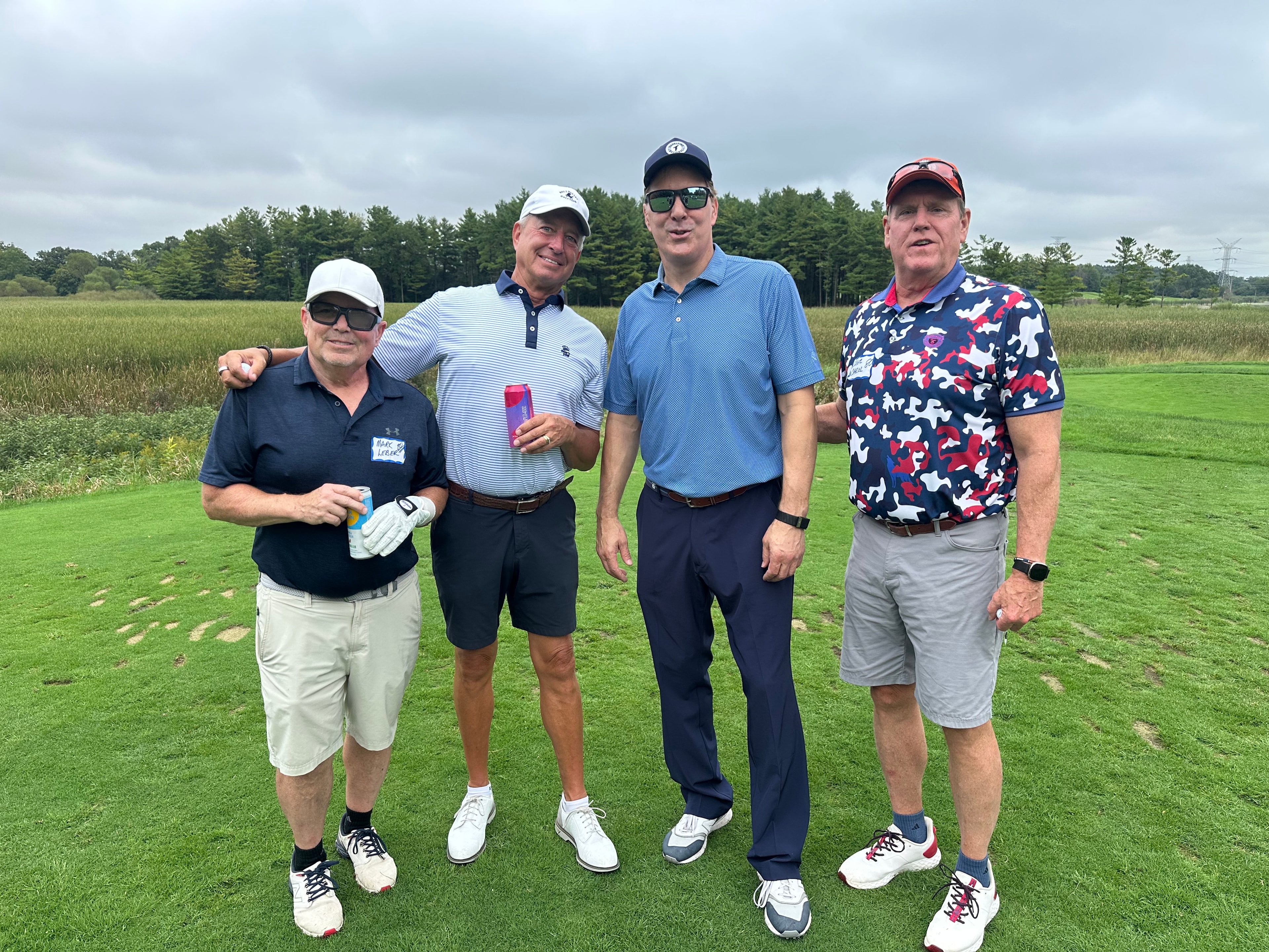 Four men posing on golf course