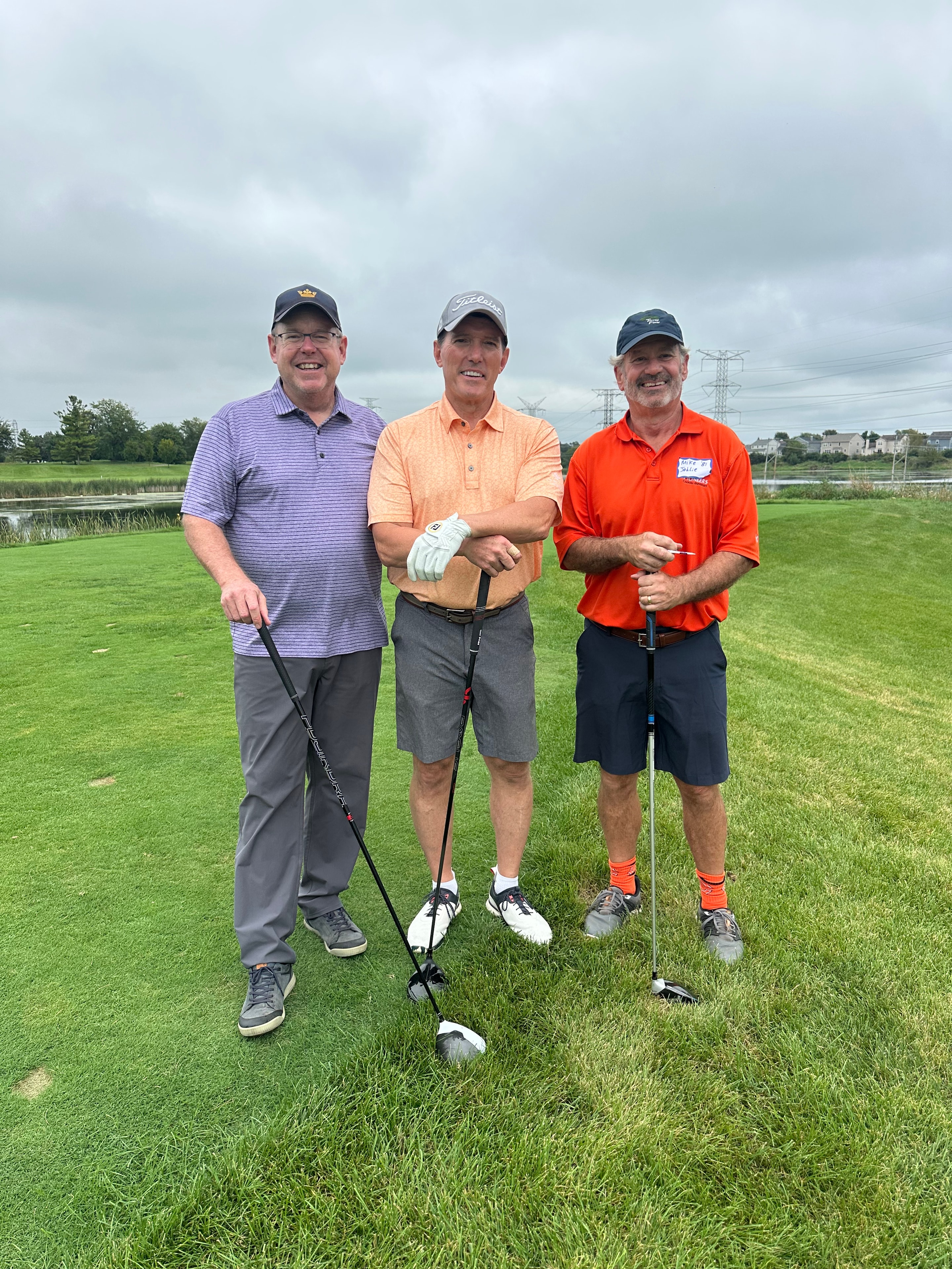 Three men golfing on course together