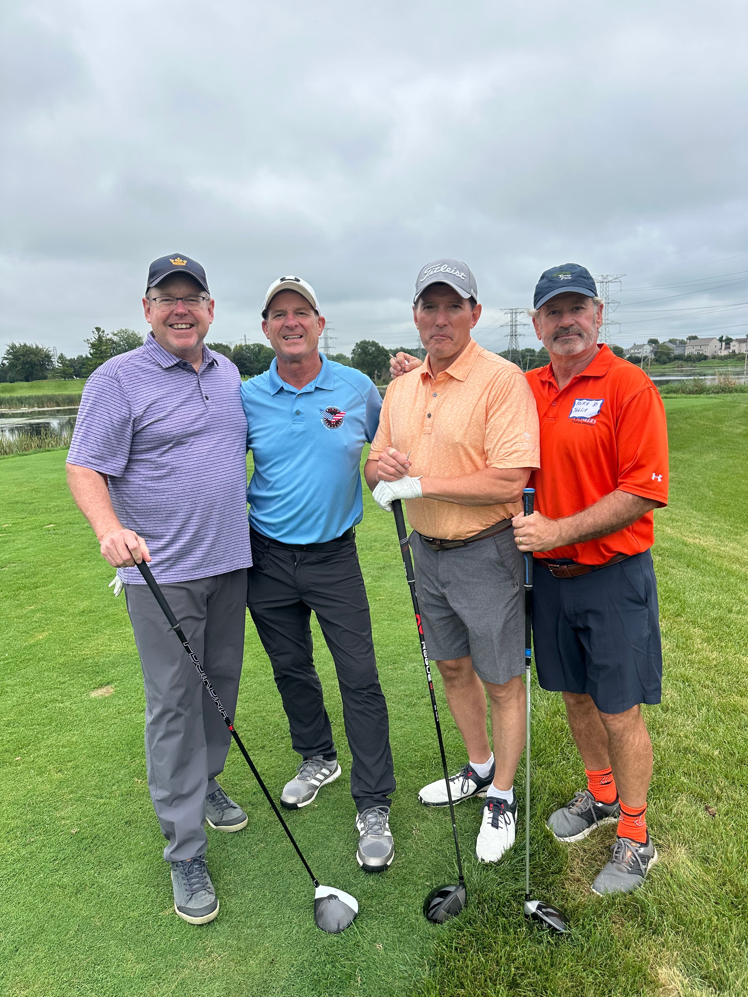 Four men golfing together on course
