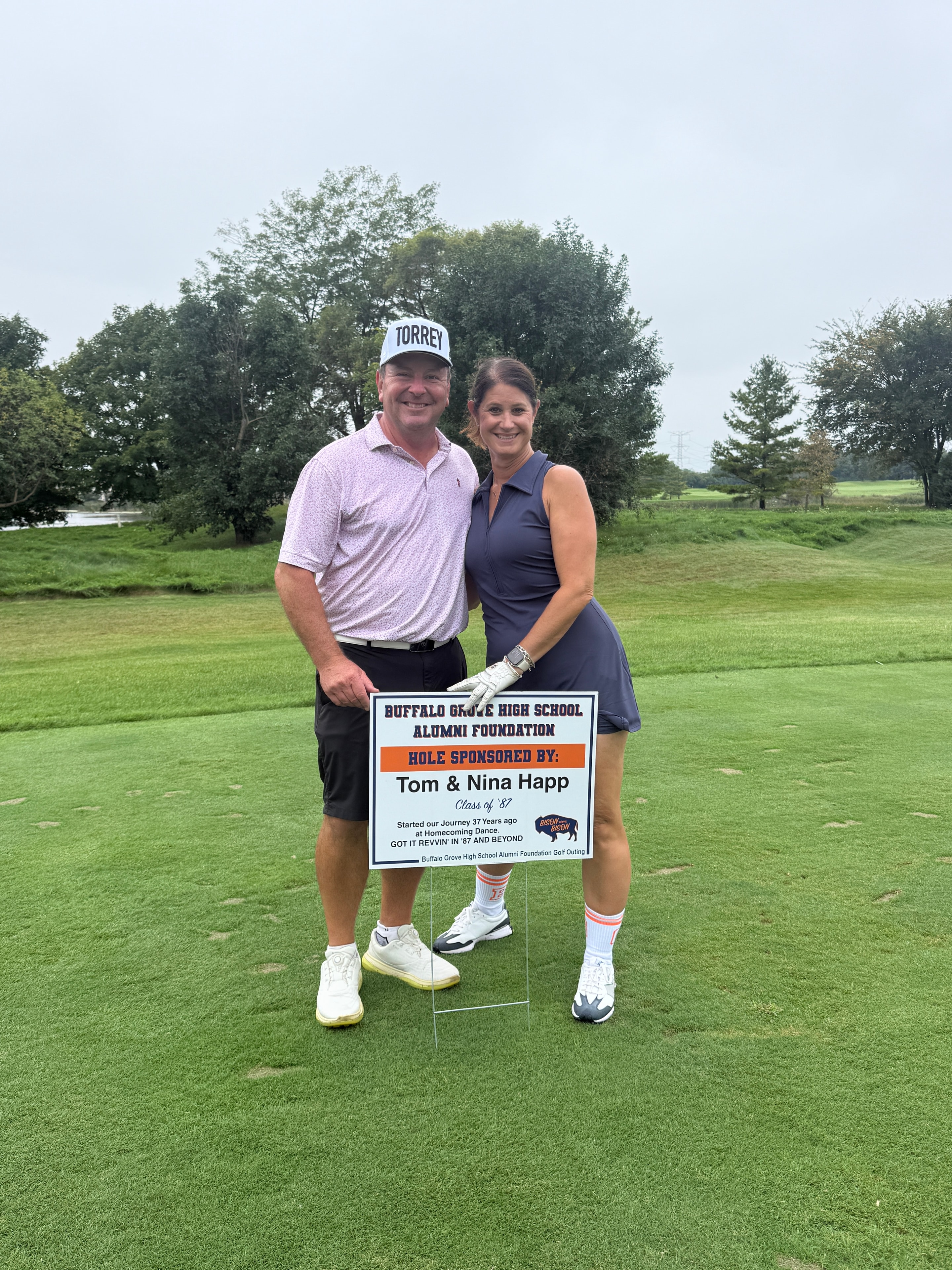 Couple posing at golf course charity event