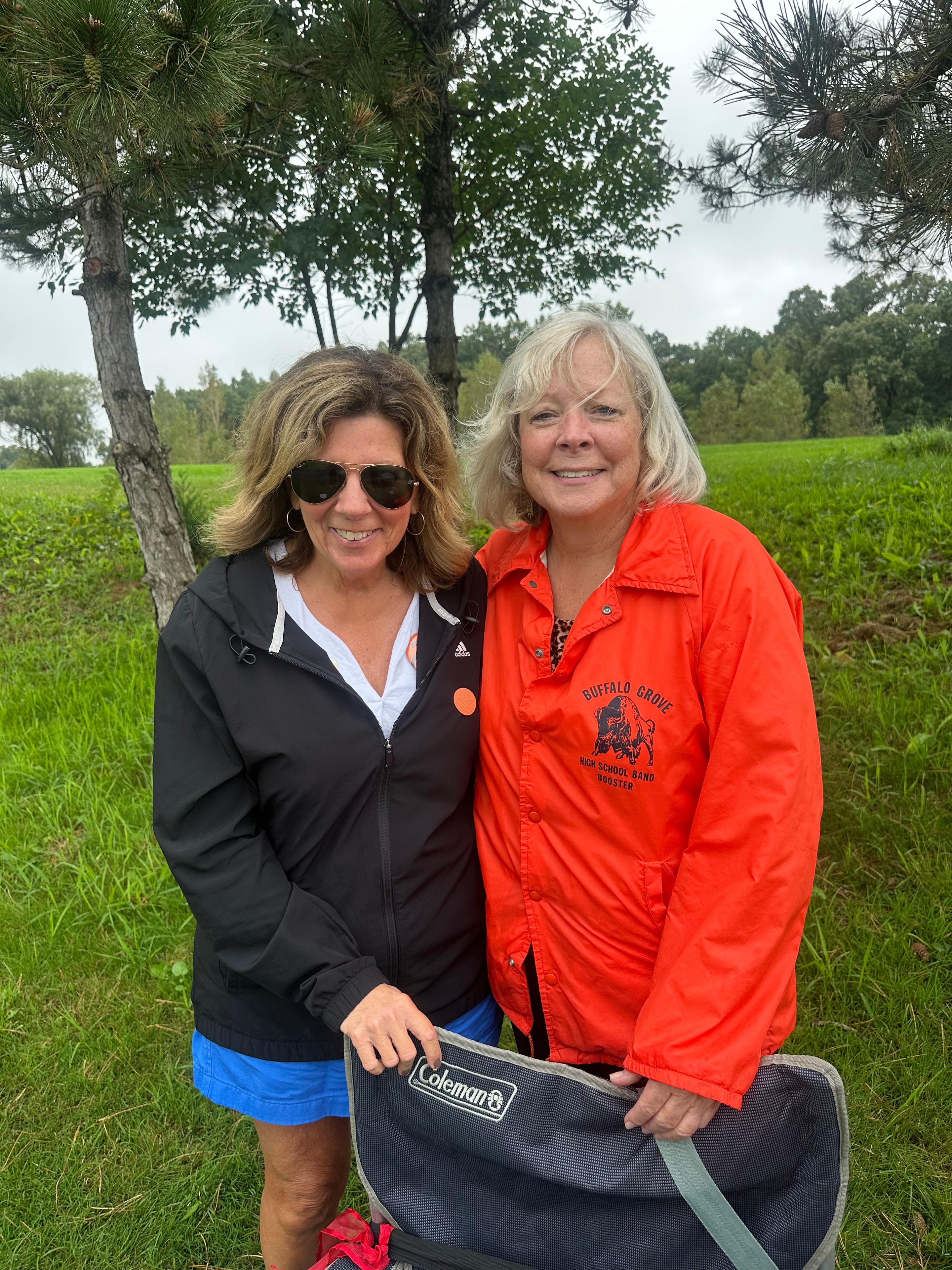 Two women posing outdoor field portrait