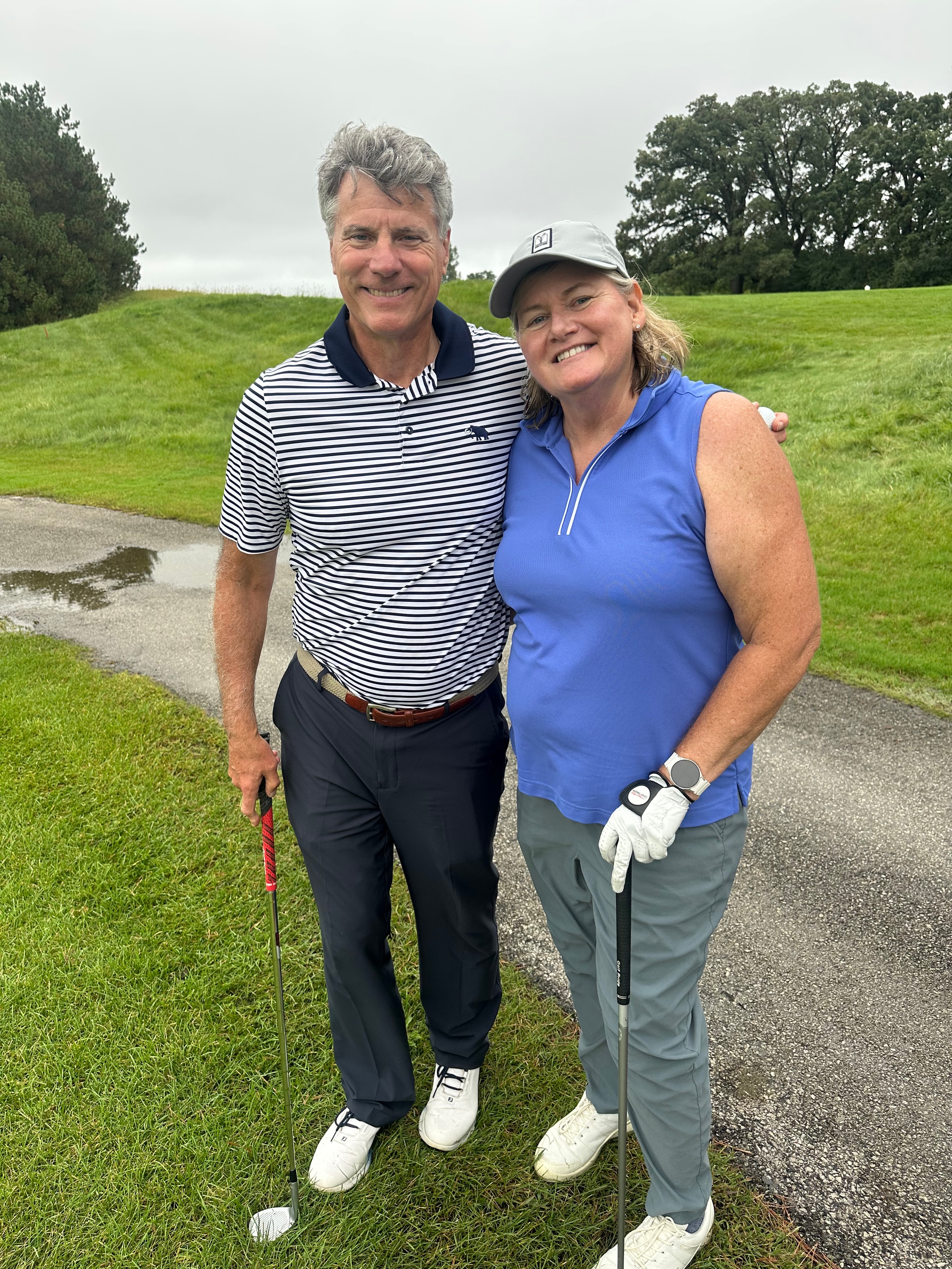 Two golfers posing on green course
