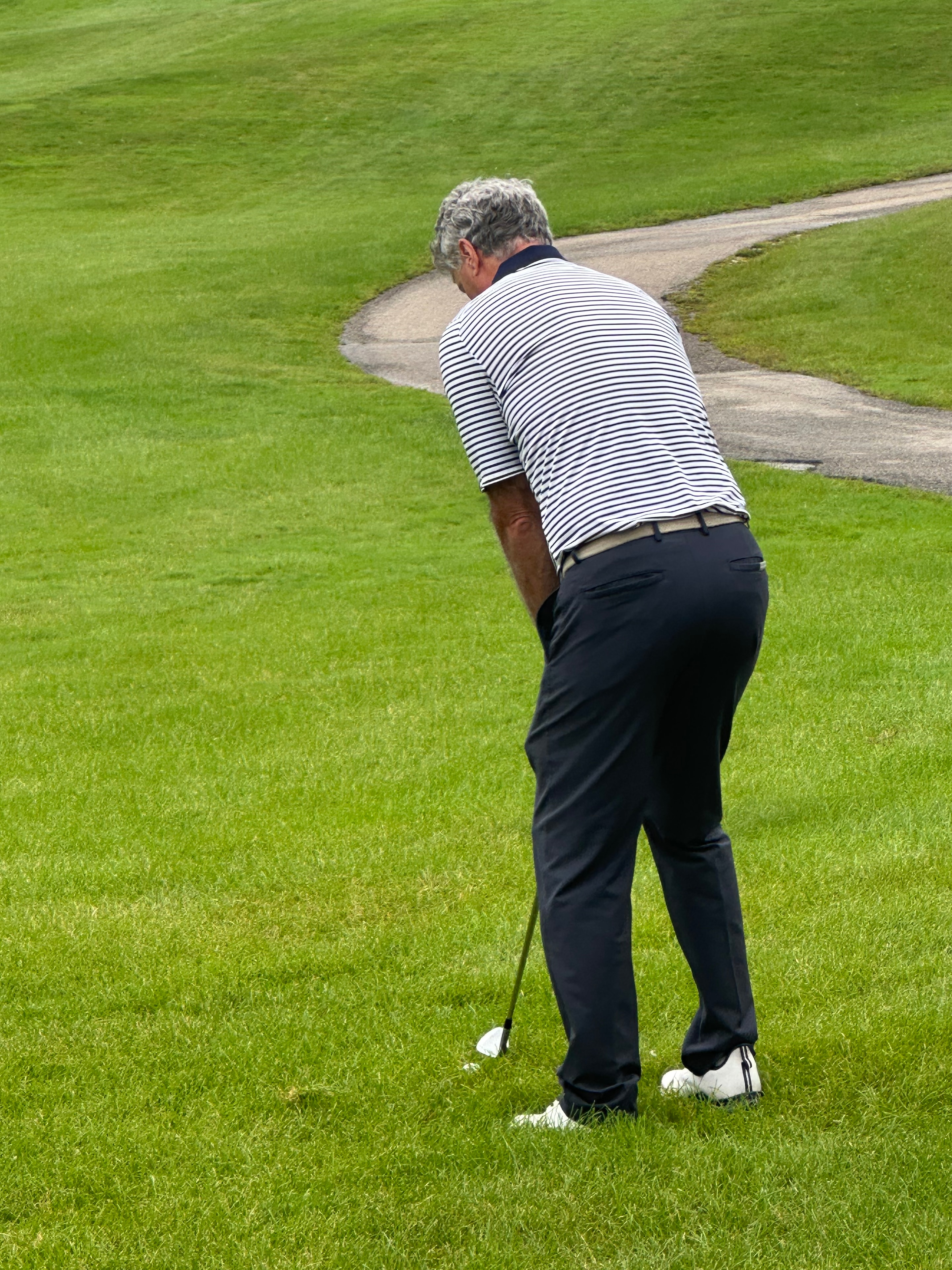 Senior golfer swinging on fairway