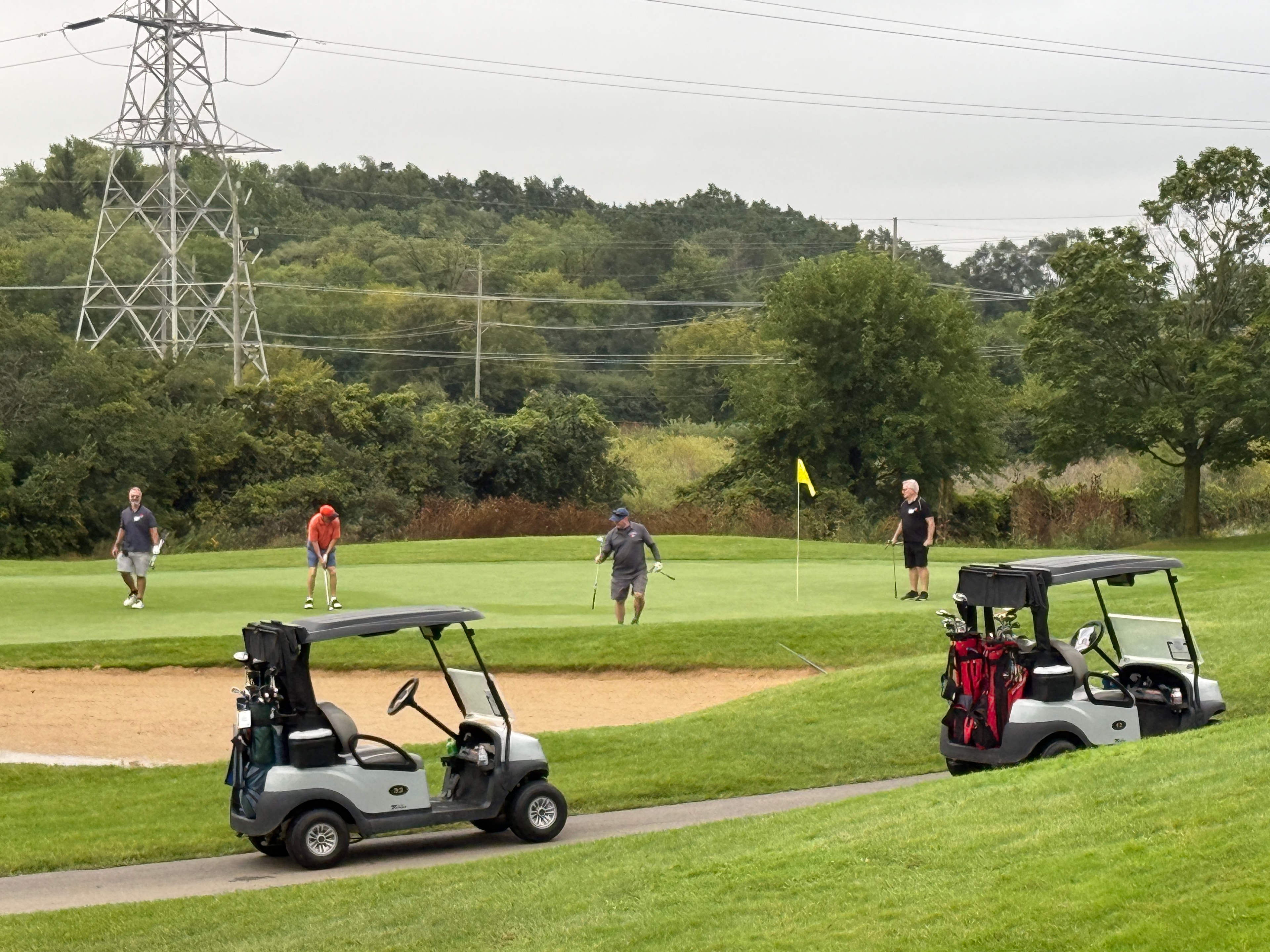 Golfers playing course near power lines