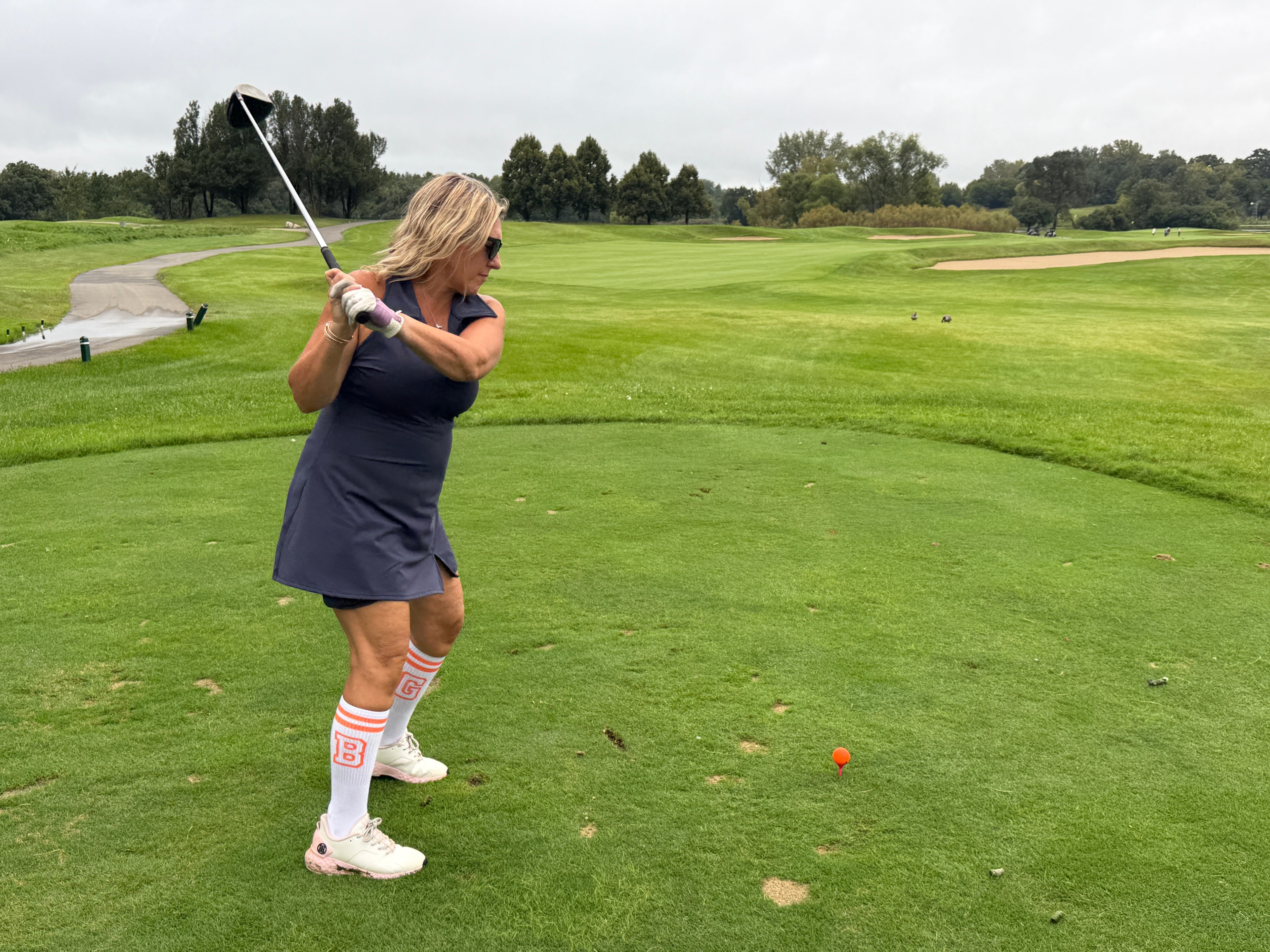 Woman golfing on fairway with club