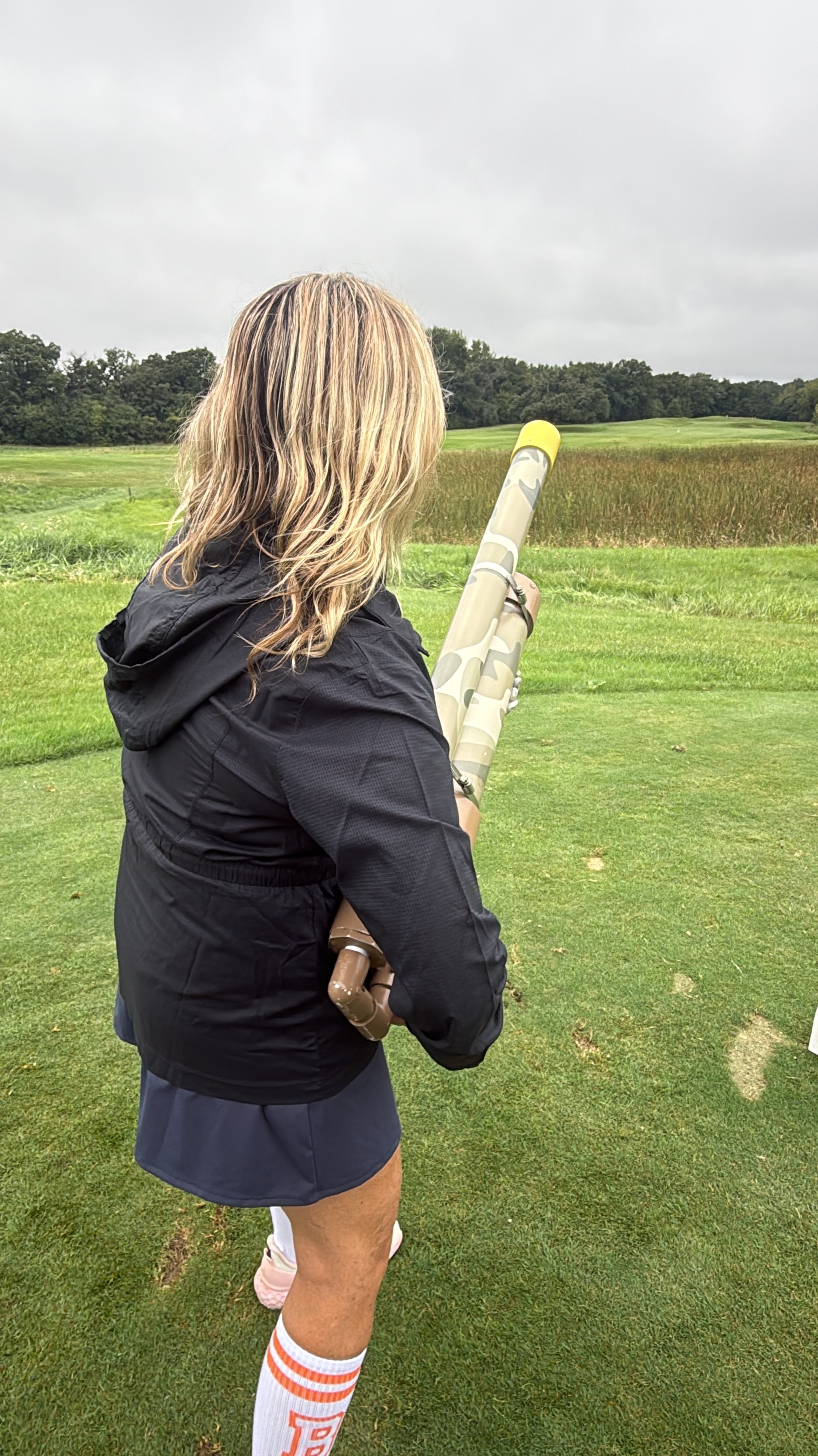 Woman with golf ball cannon in field