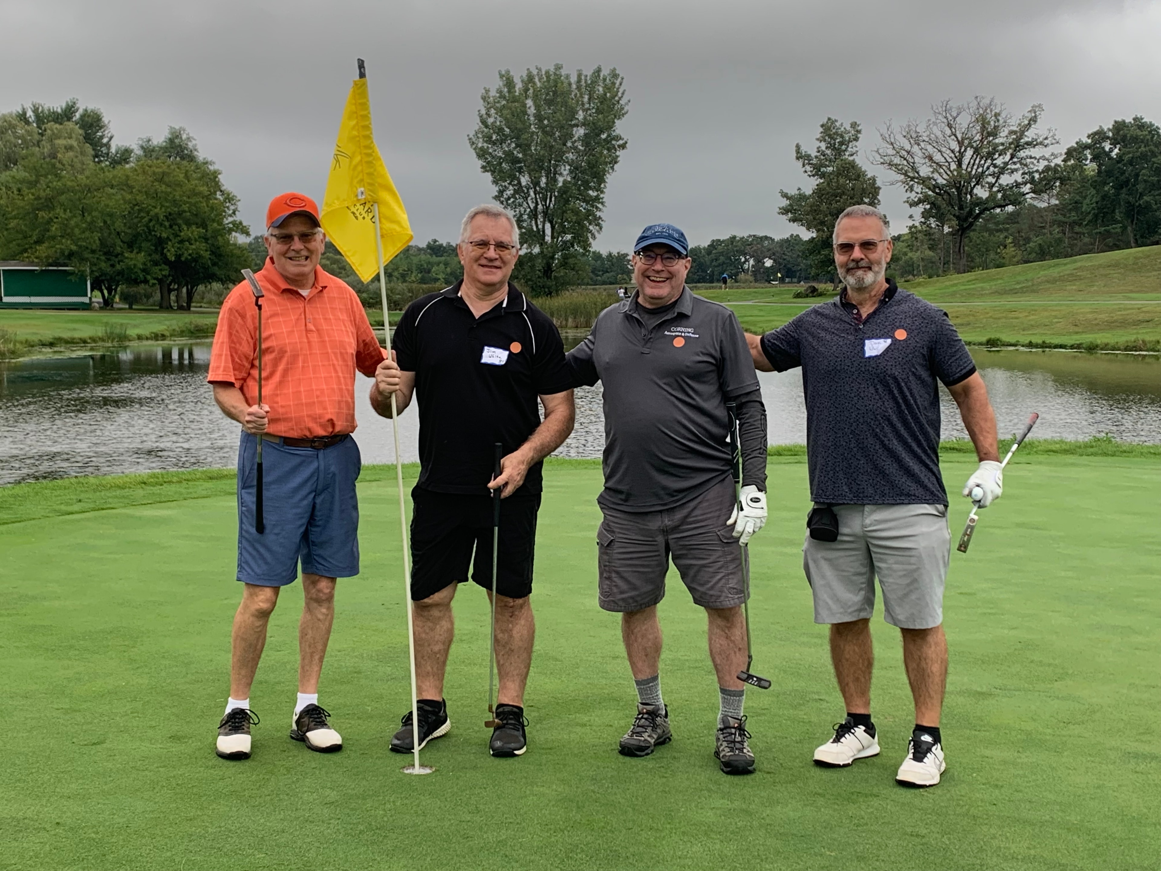 Four men posing on golf course green