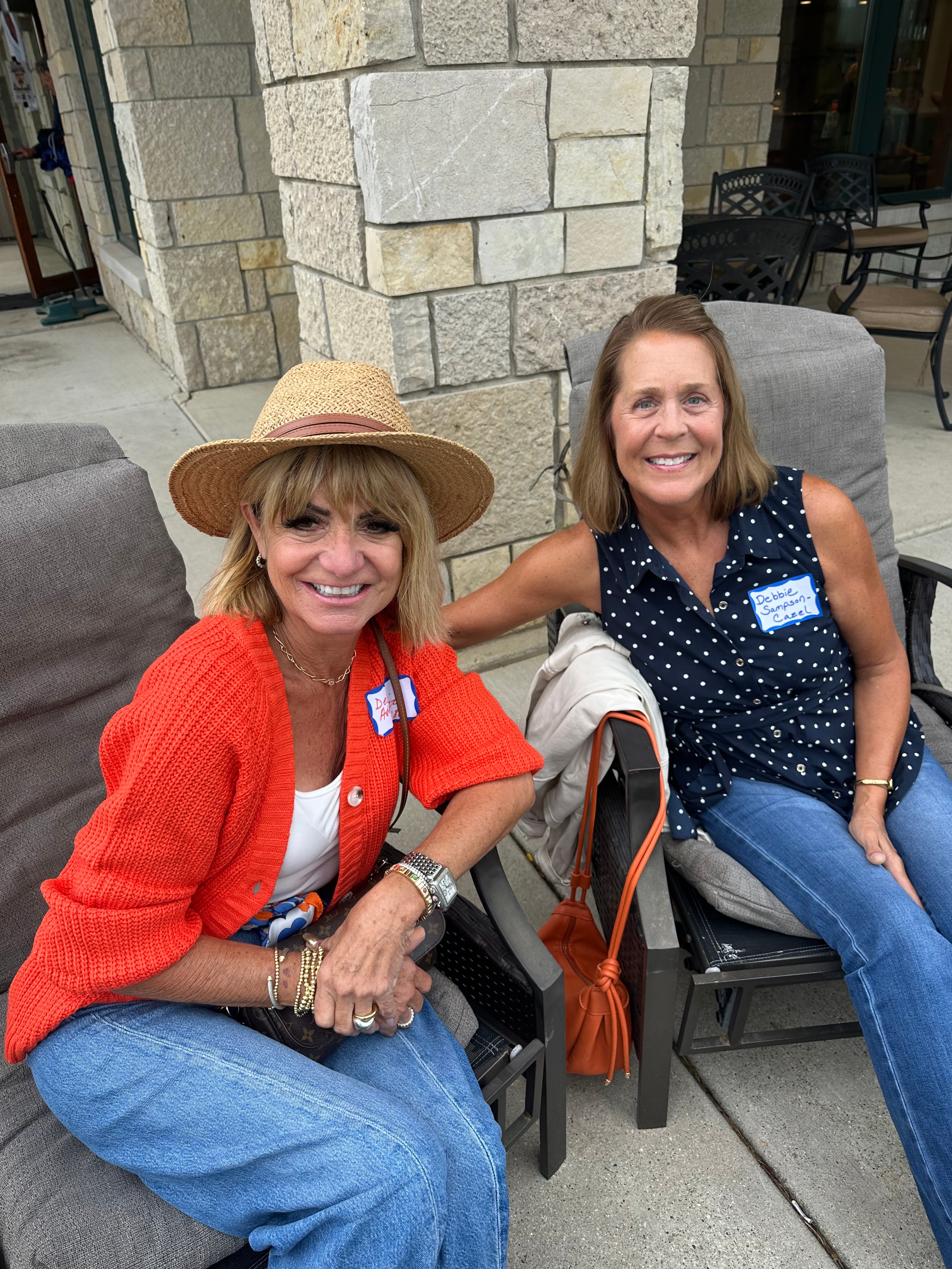 Two women smiling at outdoor patio seating