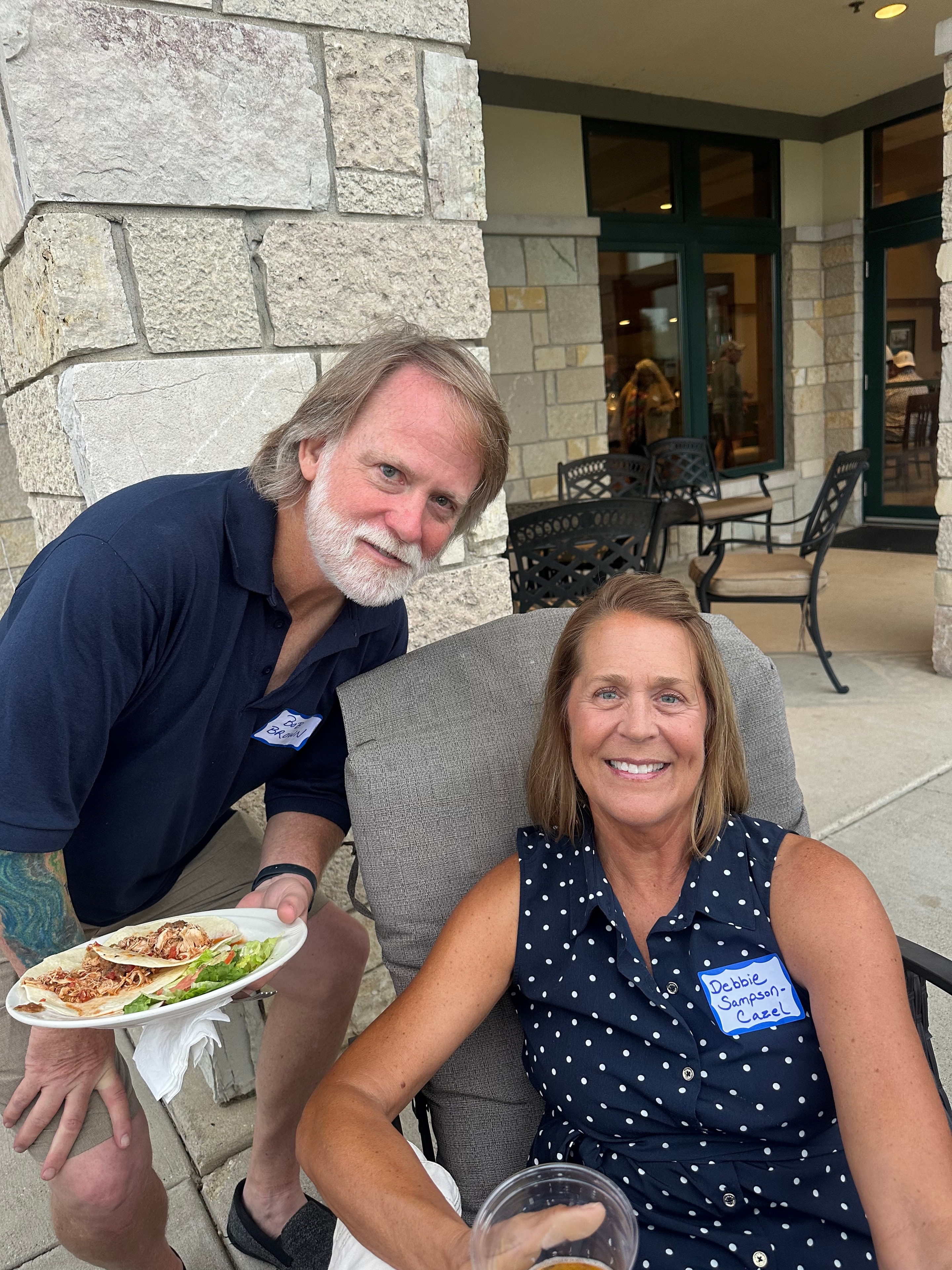 Man serving food to woman at outdoor patio