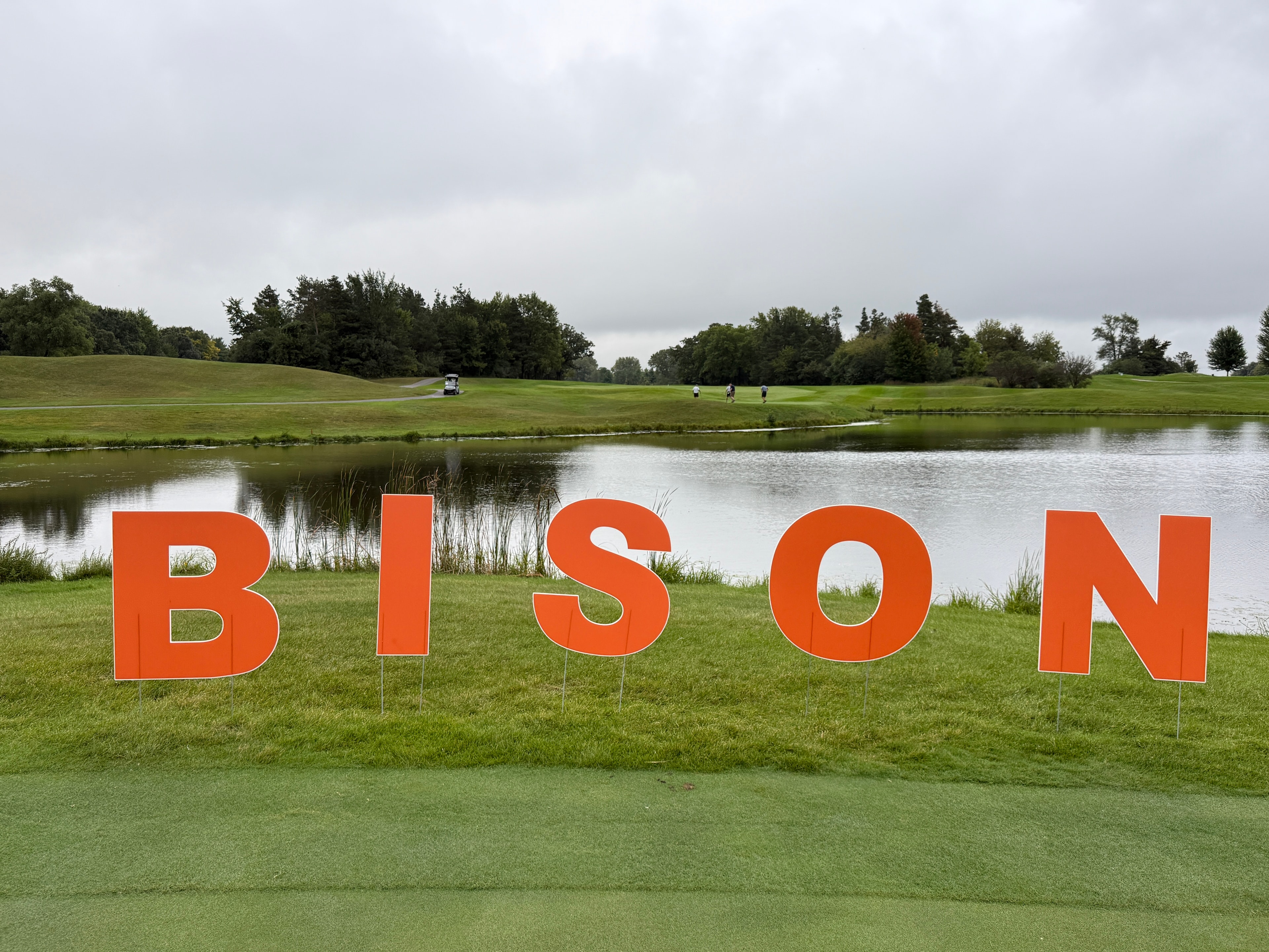 Bison sign by golf course pond landscape