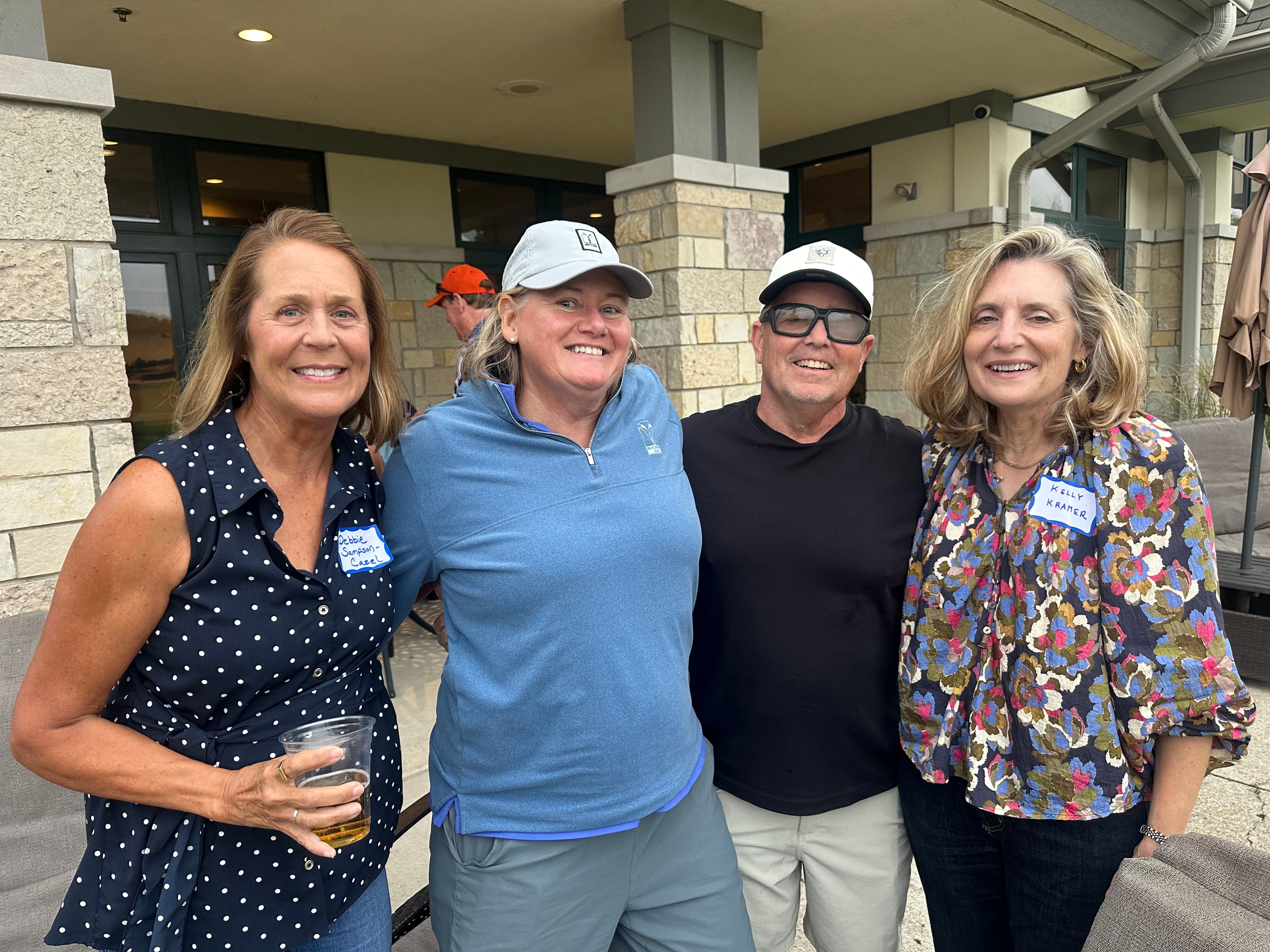 Four adults smiling at outdoor event