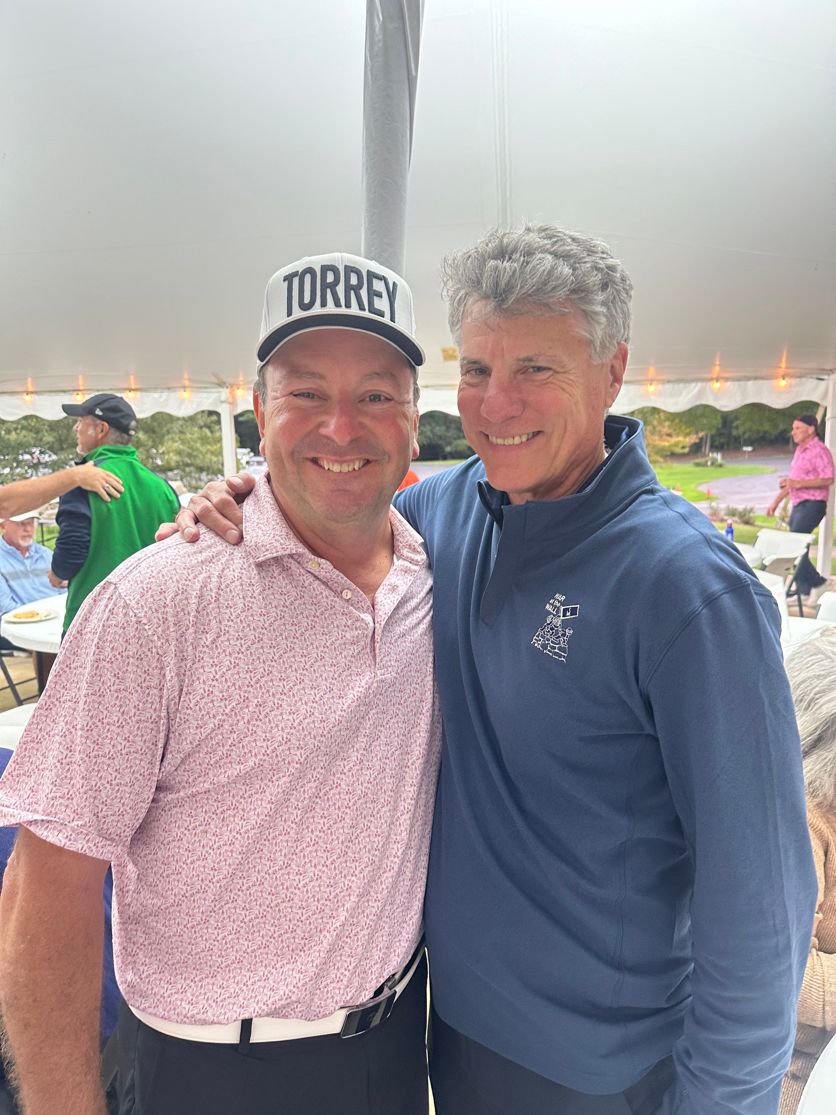 Two men smiling at outdoor event