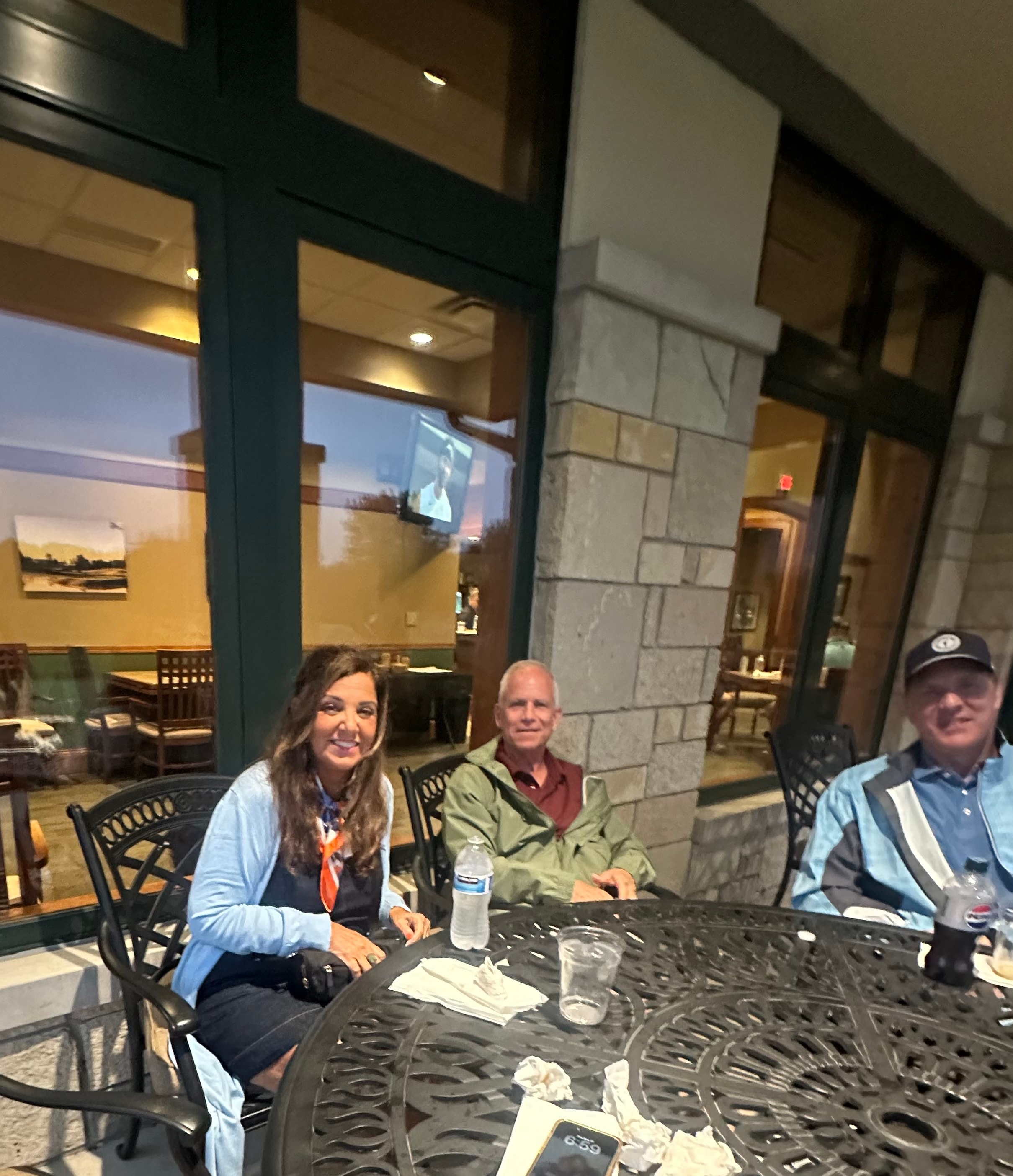 Three people dining at outdoor patio table