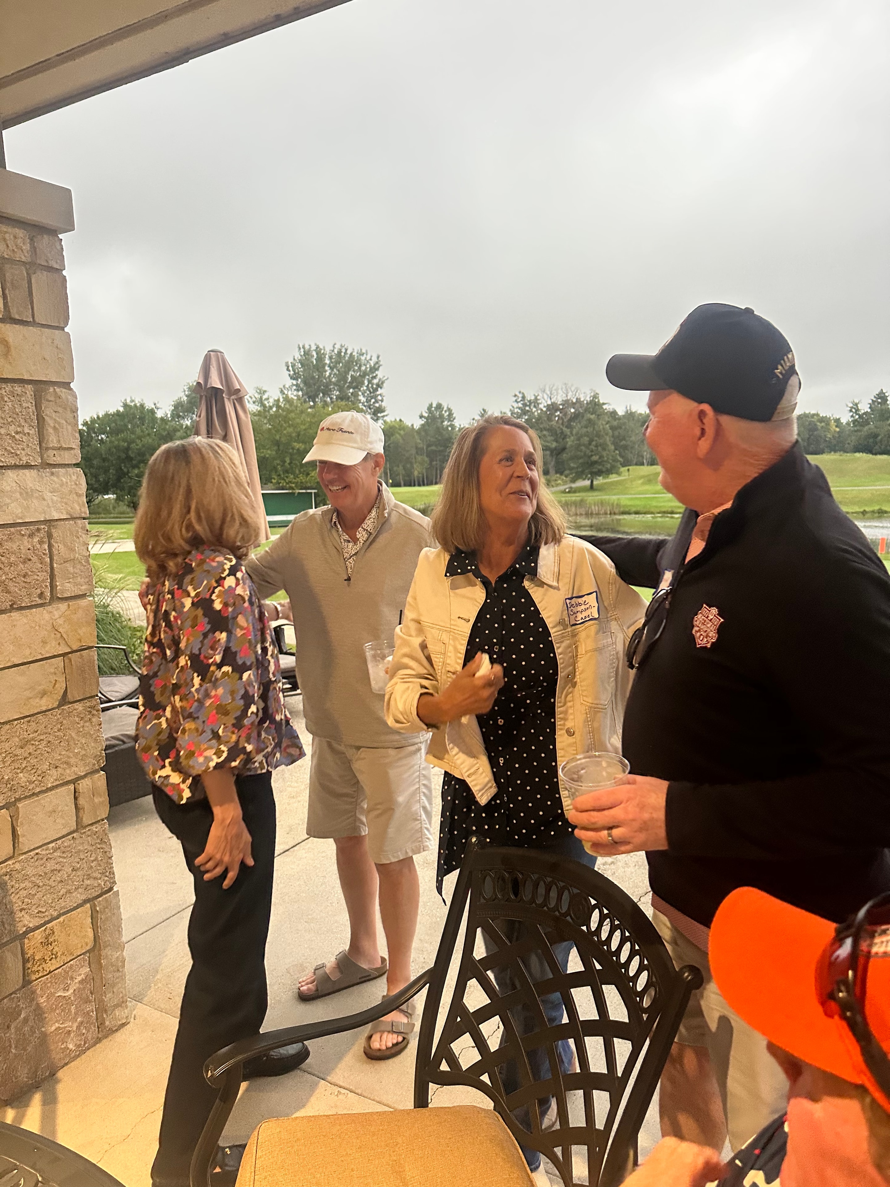 Group socializing on golf course patio