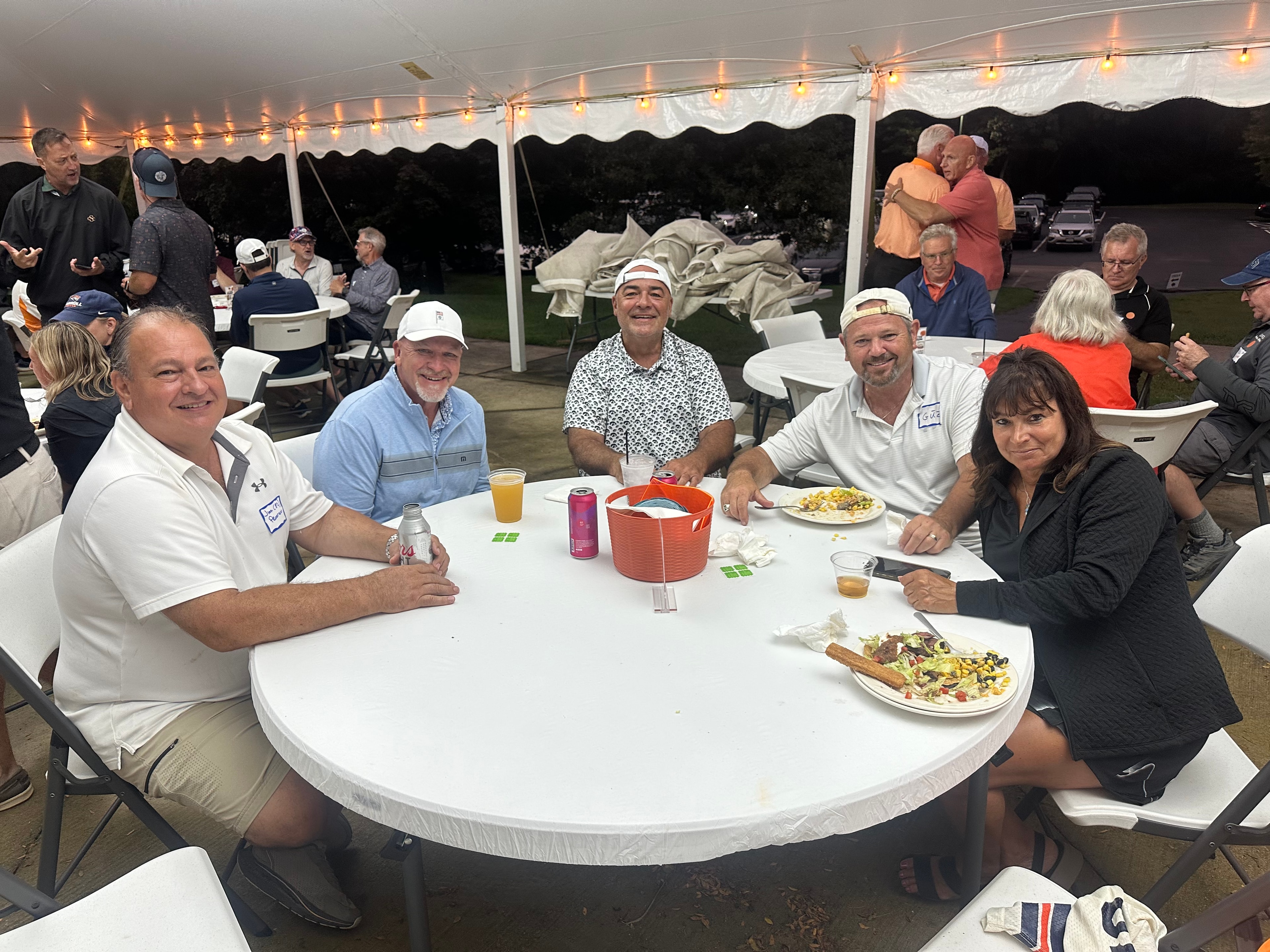 Group dining under tent at evening event