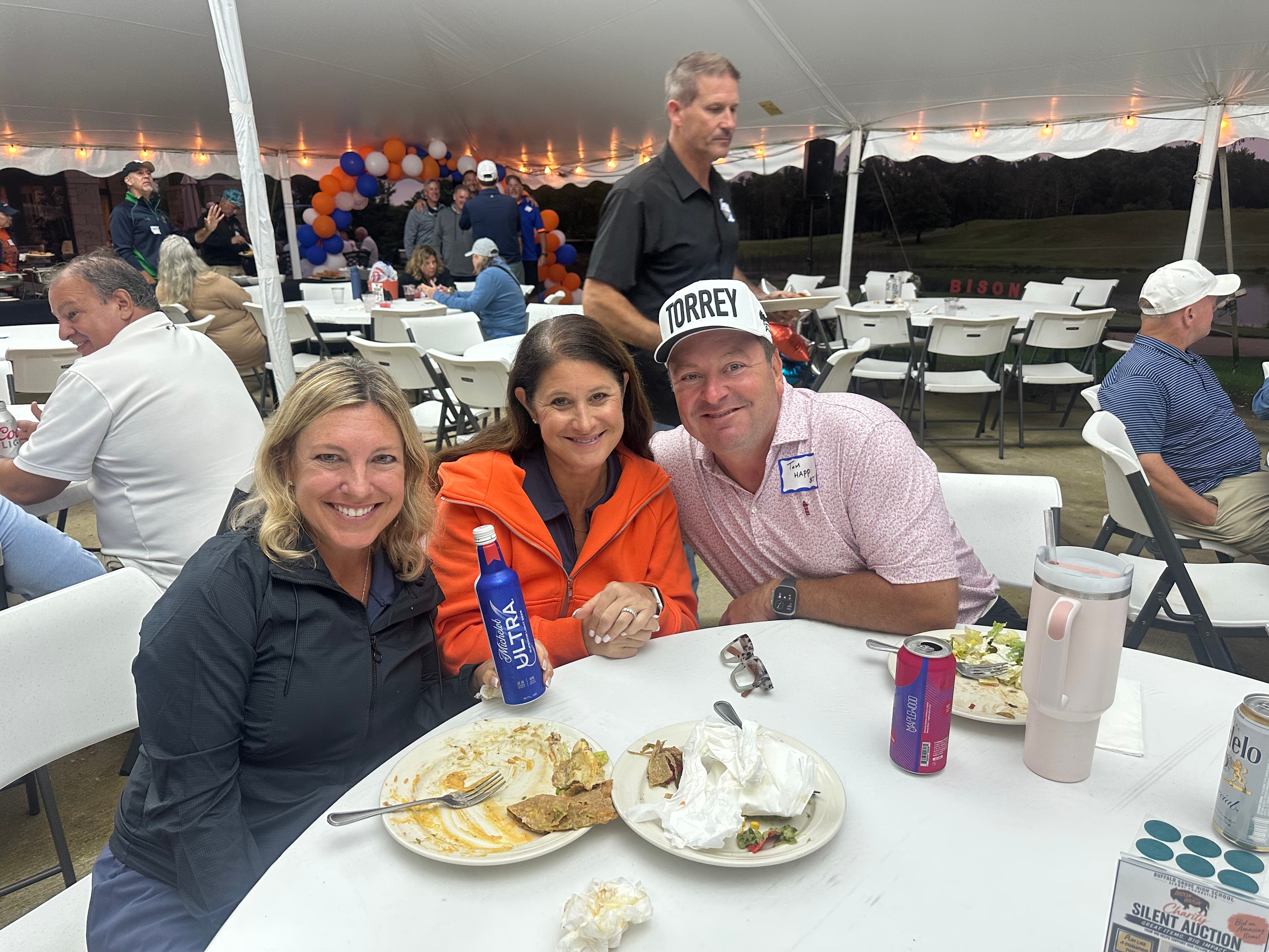 Three people dining at outdoor tent event