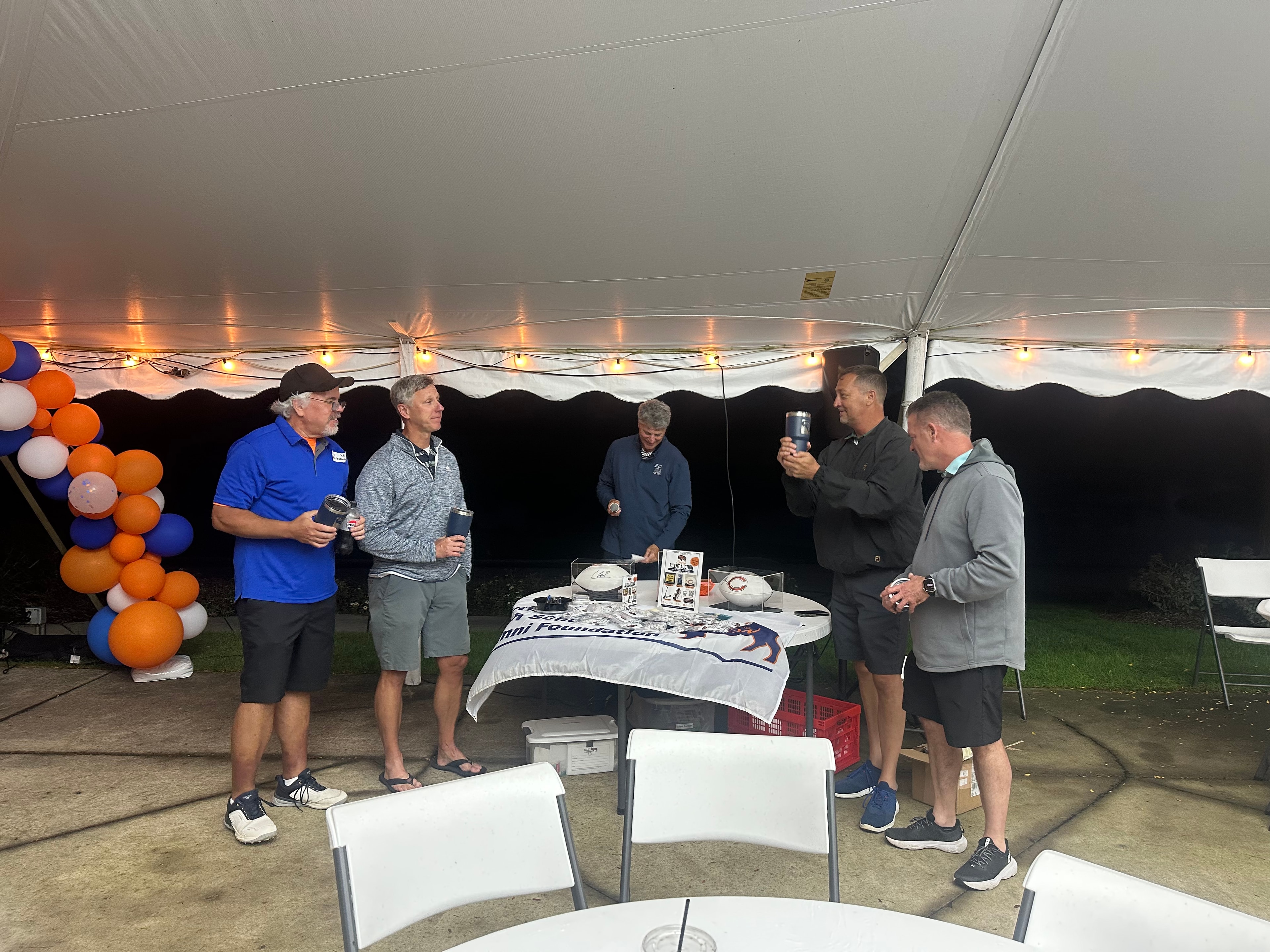 Men gathering under tent at event