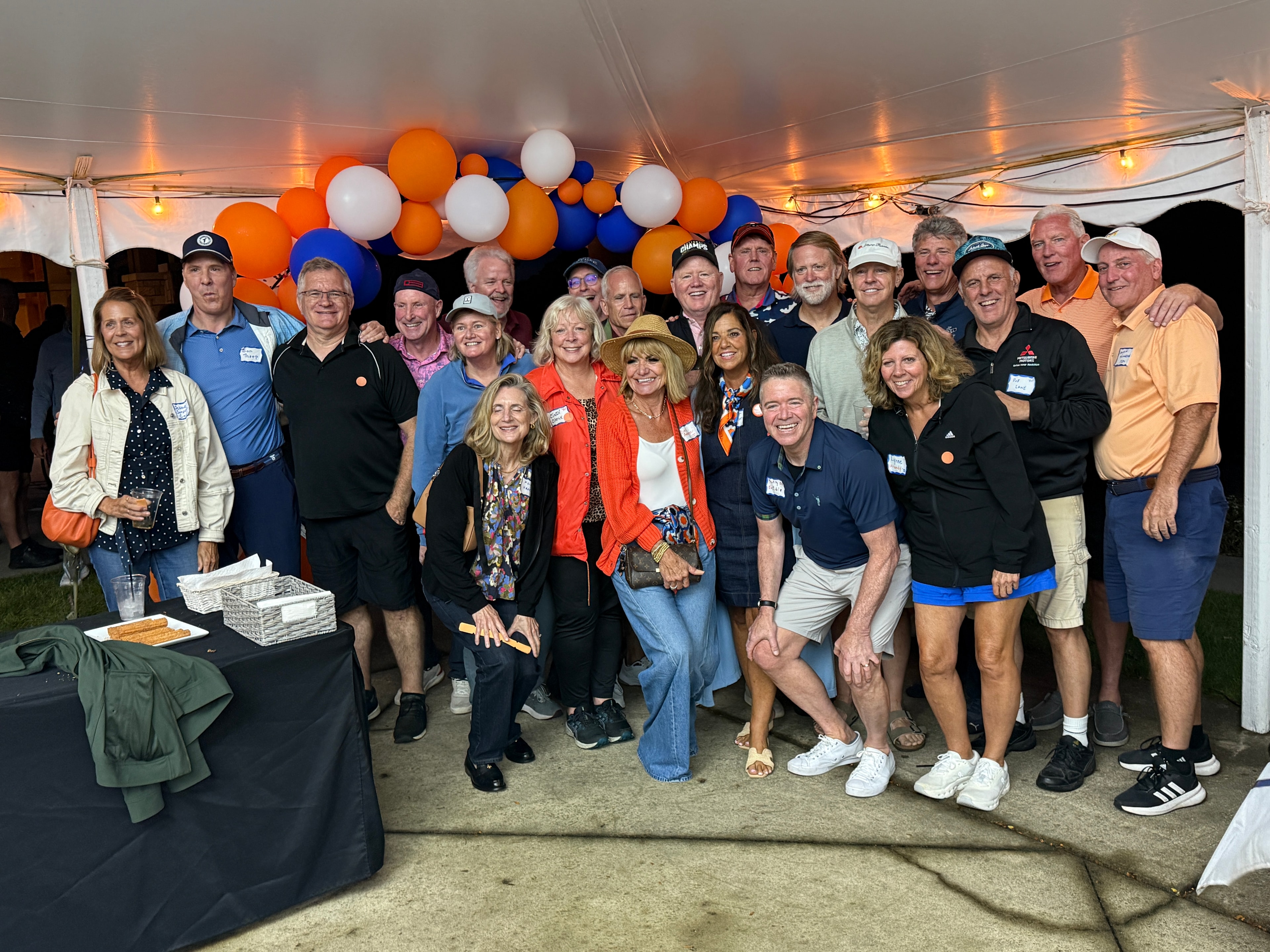 Large group posing at festive tent event