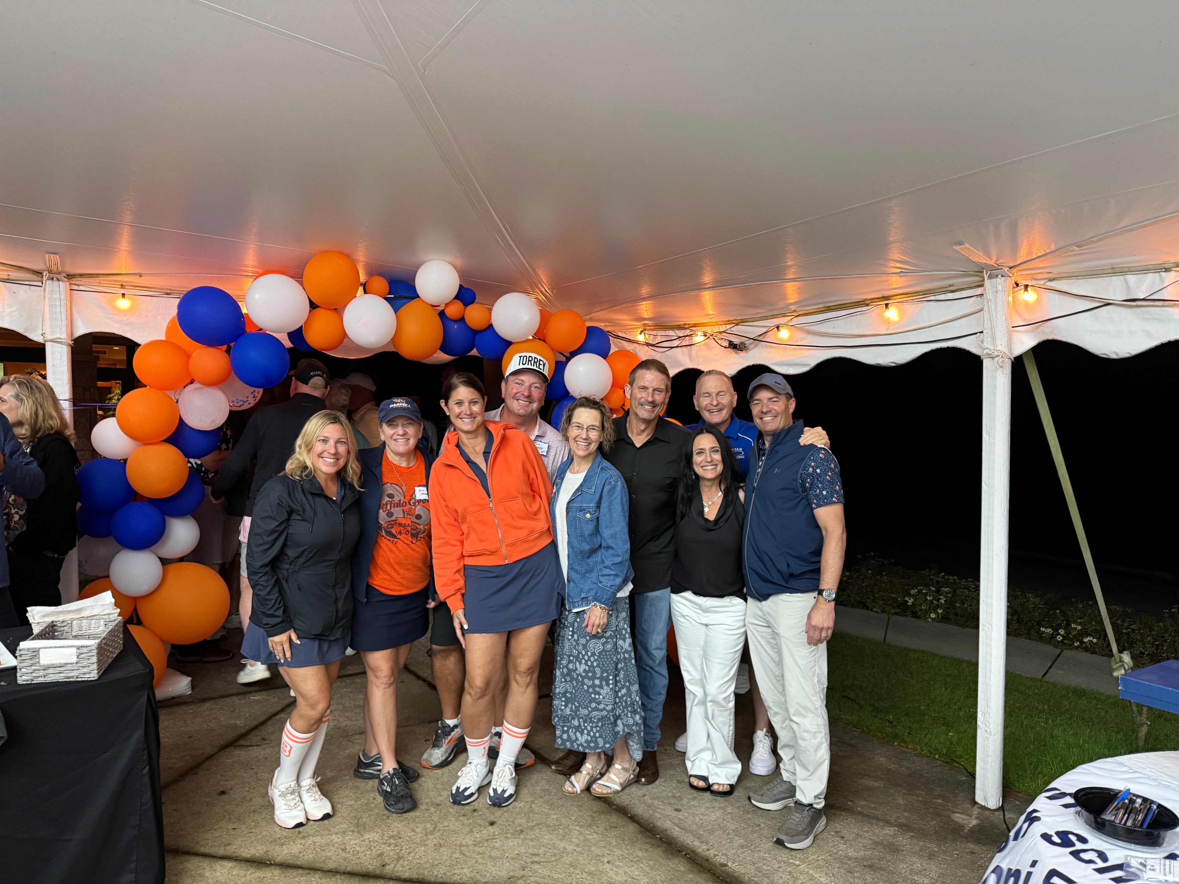 Group posing at evening tent party celebration